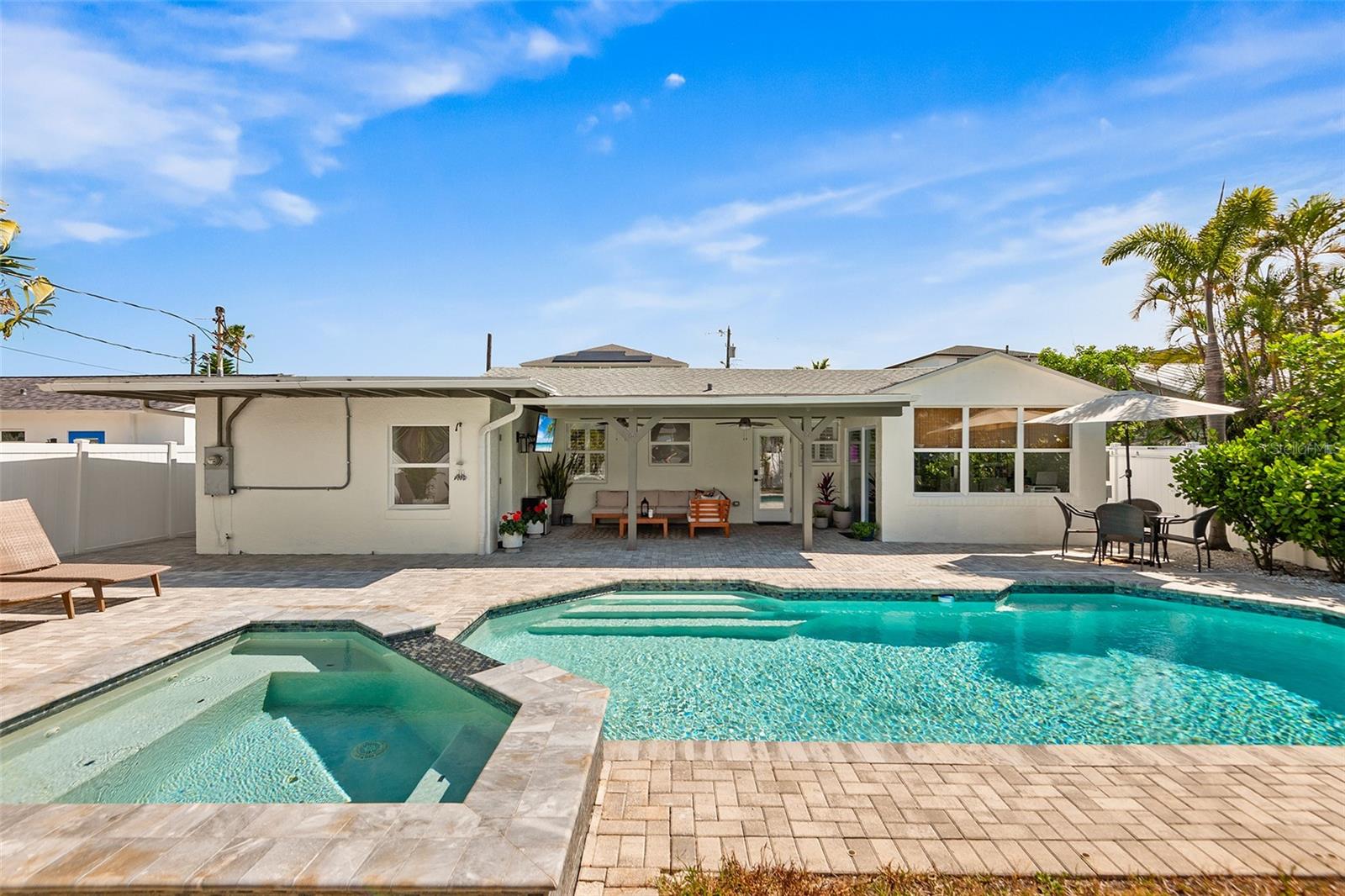 Live where every day feels like a vacation—just three blocks from the bright sugar sands of Madeira Beach and a breezy 5-minute bike ride to the vibrant shops, dining, and waterfront buzz of John's Pass Village & Boardwalk. This stunning, move-in-ready 3-bedroom, 2-bath home has been completely reimagined with high-end upgrades, including NEW hurricane-impact windows and doors, fresh exterior paint, and a striking paver circular driveway. Inside, you’re welcomed by new porcelain tile flooring and a beautifully redesigned kitchen featuring sleek cabinetry, leathered granite countertops, updated lighting, modern backsplash, and brand new appliances. The newly renovated office space with barn doors could also function as a 4th bedroom. Step outside into your own private resort-style retreat. The heated saltwater pool and spa, complete with a cascading waterfall, ambient lighting, and outdoor shower create the perfect setting for both relaxing evenings and unforgettable gatherings. A new expanded paver patio adds effortless style and low-maintenance outdoor living. Every detail has been thoughtfully considered, including custom closet systems throughout and a spacious walk-in closet in the primary suite along with a brand new spa-inspired primary bathroom. The updated garage is perfectly suited for a golf cart, beach gear, and all your coastal essentials, complemented by a new tankless water heater. Framed by fresh landscaping, this home seamlessly blends luxury, comfort, and an unbeatable location—making it an exceptional primary residence, vacation escape, or high-performing investment near the Gulf.