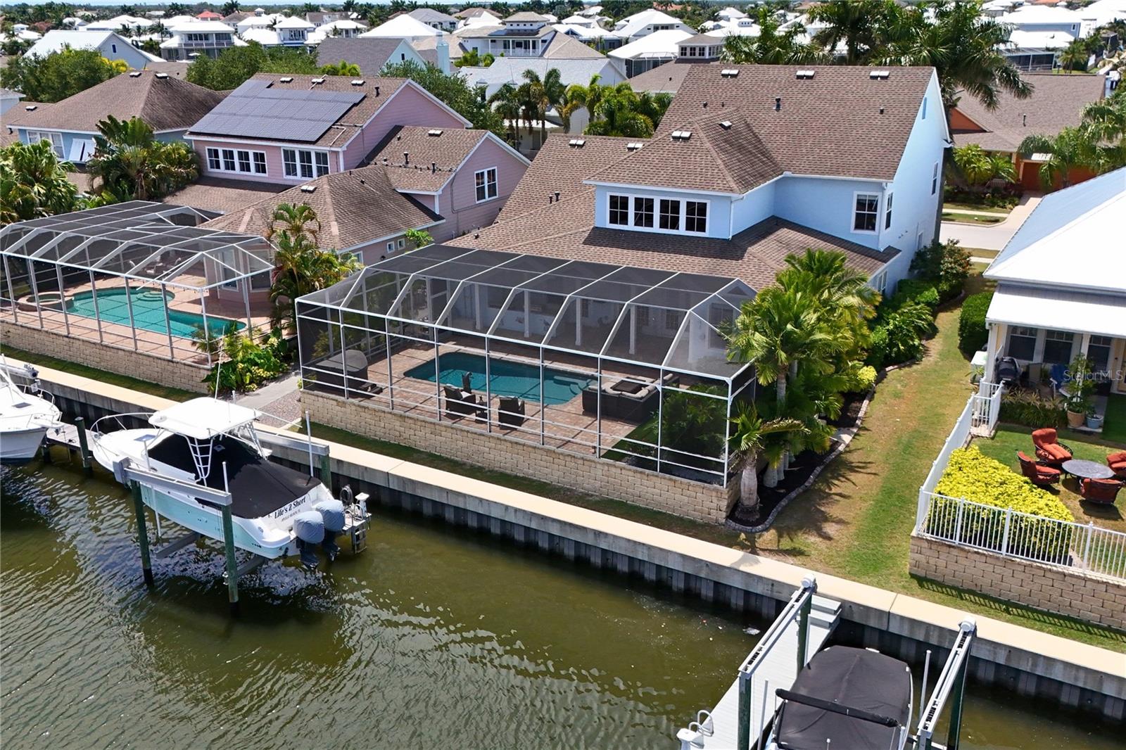 Welcome to your own private waterfront retreat in the highly sought-after community of MiraBay in Apollo Beach, where luxury, comfort, and an active coastal lifestyle come together seamlessly. Perfectly positioned on the water with direct access to Tampa Bay in approximately 10 minutes, this beautifully upgraded custom-built David Weekley “Sand Dollar” model offers the ideal setting for families who love entertaining, boating, and making memories together.
From the moment you arrive, the home’s impressive curb appeal, expansive layout, and thoughtfully designed indoor-outdoor spaces create an inviting atmosphere that feels both elegant and comfortable. Inside, the spacious floor plan offers flexibility for growing families with a large private office featuring French doors, perfect for working from home, a playroom, or study space.
At the center of the home is an oversized gourmet kitchen designed for gathering and connection. Featuring upgraded Silestone countertops, upgraded 42-inch cherry cabinetry with glass inserts, stainless steel appliances including a new refrigerator, dishwasher, and microwave, double ovens, gas cooking, a large center island, and an expansive breakfast bar, this kitchen provides exceptional storage, prep space, and seating for everyday family living and entertaining alike. The adjoining family room creates a warm and welcoming space with a custom built-in entertainment center, electric fireplace, and accent lighting that makes evenings at home feel cozy and inviting.
Upstairs, a dedicated theater/media room offers the perfect place for movie nights, gaming, or relaxing together after a day on the water. The oversized primary suite serves as a peaceful retreat, a spacious walk-in closet, dual vanities, and a luxurious bath featuring a Jacuzzi jetted tub. Additional storage beneath the staircase and throughout the home adds both convenience and functionality for busy family life.

Outdoor living is where this home truly shines. The expansive screened paver lanai is designed for year-round enjoyment and entertaining, complete with a recently resurfaced pool, built-in LED lighting, generous covered seating areas, and a fully equipped outdoor kitchen with grill and prep space. The pet-friendly turf area creates a safe and low-maintenance space for children and pets to play while enjoying the beautiful waterfront setting.

For boating enthusiasts, the private dock and 16,000 lb boat lift provide quick and convenient access to Tampa Bay, making sunset cruises, fishing trips, and weekends on the water part of everyday life.
Located within the resort-style community of MiraBay, residents enjoy access to outstanding amenities including a clubhouse with fitness center, heated pool with slide, pool side cafe, 4 clay tennis courts, 4 new pickleball courts, 2 basketball courts, playgrounds, parks, walking trails, community events, and a stunning 136-acre lagoon ideal for kayaking, paddle boarding, canoeing, and sailing.
This exceptional waterfront home offers the perfect balance of luxury, recreation, family-friendly living, and the Florida lifestyle so many dream about. Schedule your private showing today.