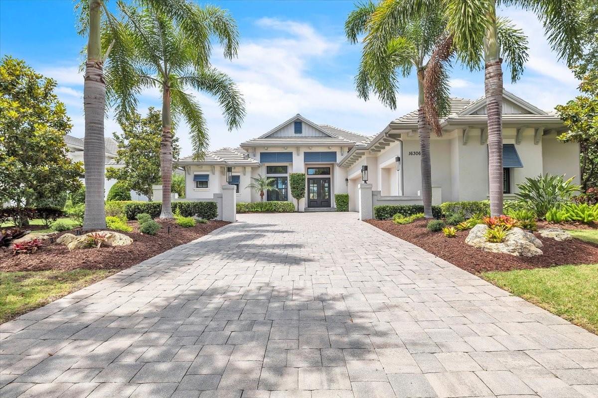 GORGEOUS. Welcome to luxury lakefront living in The Lake Club at Lakewood Ranch. Built in 2018 by Stock Custom Homes, this rare Merano model offers 3,600 square feet of impeccably maintained living space with 3 bedrooms, 4 bathrooms, a private den, bonus room, and an expansive premium lakefront setting that captures breathtaking water views from nearly every angle.

Lovingly maintained by its original owner, this gorgeous residence combines timeless elegance with thoughtful upgrades throughout. A dramatic two-tier elevation, stone decorative exterior trim, sealed concrete tile hip roof, and oversized paver driveway create stunning curb appeal from the moment you arrive. Inside, soaring ceilings—including a 14-foot coffered great room and 14-foot foyer—enhance the home’s open, airy feel, while crown molding, upgraded lighting, porcelain tile flooring, and designer finishes elevate every space.

The grand entry features custom bronzed iron doors, polished marble decorative tile, and a designer light fixture that sets the tone for the luxurious interior. The great room is designed for both entertaining and everyday comfort, showcasing a custom entertainment wall with floating cabinetry, shelving, underlighting, premium ceiling fan, and 10-foot impact glass sliders opening seamlessly to the expansive lanai.

At the heart of the home is a chef-inspired kitchen featuring premium Monogram appliances, warming drawer, oversized Fantasy Brown granite island with rounded edges, Level 6 solid wood cabinetry with underlighting, upgraded pendant lighting, custom ceiling-finished exhaust, and a large walk-in pantry. Adjacent dining spaces include a beautifully detailed breakfast nook with decorative drop ceiling and designer fixture.

The spacious primary suite is a private retreat with tray ceilings, crown molding, premium fan/light, custom shutter-style wood blinds, direct lanai access, upgraded dual sinks, and a spa-like bath with floor-to-ceiling tile shower. Two guest bedrooms serve as luxurious en-suites complete with walk-in closets, crown molding, custom shutters, premium lighting, Moen fixtures, and floor-to-ceiling tiled showers. A flexible bonus room—with added closets, tray ceiling, crown molding, and remote Lutron shades—offers the perfect fourth bedroom, media room, or private retreat.

Outdoor living is exceptional. Enjoy panoramic lake views from the resort-style lanai featuring a gas-heated pool and spa with auto-fill and sun shelf, shell stone pavers, custom TV wall, outdoor shower, summer kitchen, smart pool controls, three ceiling fans, extra lighting, and elegant colonnade-style screen supports.

Additional upgrades include:
• Impact glass throughout, insulated and tinted
• Remote Lutron sun shades
• Oversized garage with epoxy floors and extra storage
• Whole-house Generac generator
• Tankless water heater with recirculator
• Double whole-house surge protection
• Two HVAC systems with smart thermostats, UV air purification, and MERV 10+ filtration
• Upgraded landscaping, French drains, rain gutters, and noise-reducing equipment walls
• Solid surface window sills throughout

This immaculate home offers luxury, quality construction, and exceptional value in one of Southwest Florida’s premier gated communities. Rarely does a Merano model with this level of upgrades and such an incredible lake view become available.