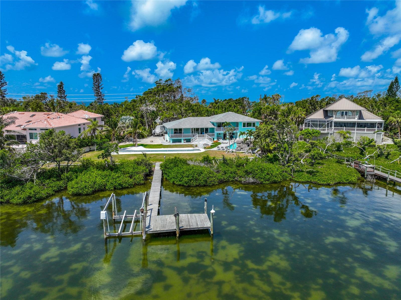 One or more photo(s) has been virtually staged. This extraordinary island property offers a rare opportunity to own a piece of paradise in one of Florida's most sought-after coastal destinations. Nestled on a pristine stretch of Manasota Key, this private estate boasts unparalleled panoramic views of Lemon Bay. From the comfort of your deck, or sitting on the dock, indulge in the captivating water vistas that stretch as far as the eye can see. Ready to hit the beach? Conveniently located just a short distance across the street is a deeded beach access allowing you to enjoy the white sand beaches and tranquil waves at your leisure.
The exterior of this beautiful island home is a testament to life on a Florida key. The landscaped gardens and mature trees are illuminated to complement the property. The outdoor oasis has a heated swimming pool featuring a grotto, fire accents, and a soothing waterfall. The backyard amenities continue to impress with an outdoor shower, shuffleboard court, a white sandy play area, and a cozy fire pit. You'll have endless opportunities for outdoor enjoyment and entertainment.
The private dock sits in front of an approx. 88ft wide sea wall offering easy access for your boat, kayaks, and paddleboards! It extends about 300ft directly into Lemon Bay. The water depth at low tide is approx. 4ft deep and there is ample space to tie off. The dock is also in the process of getting a brand new Creative Marine lift that will hold a 10,000 lb boat lift, water, and electricity.
The interior underwent a complete remodel in 2020, showcasing elegance and top-notch craftsmanship. The large chef's kitchen and dining room with views of Lemon Bay is an entertainer's dream. This space is great for gathering friends together to create your culinary masterpieces, the kitchen features a large, granite topped island, stainless steel appliances and a walk-in pantry. 
With 3 bedrooms, 3.5 bathrooms, indoor and outdoor living space, this home offers an extraordinary amount of space for entertainment and relaxation. In addition to the bedrooms, a bonus room is currently set up as a theater room, complete with programmable remote blinds, surround sound, and acoustics. Enjoy an immersive cinematic experience within the comfort of your own home.
The primary suite is a haven of luxury, featuring a private balcony overlooking Lemon Bay. Escape to this bedroom retreat to unwind and embrace the beauty of your surroundings. The spacious primary bedroom boasts intricate details, including backlit pre-lit onyx countertops with a drink fridge, heated bathroom floors, jetted spa-tub, walk-in shower with a rain showerhead and four body shower heads, plus dual vanities. The primary suite also offers a large walk-in closet with custom shelving system and an additional closet for ultimate convenience.
This residence is equipped with wireless, Bluetooth connected devices. Control the waterfall, pyro flames atop the waterfall, surround sound speakers inside and outside, lighting, security system, blinds, and more with ease.
This is a once-in-a-lifetime opportunity to embrace coastal living at its finest. Immerse yourself in the serenity of this extraordinary property, where every detail has been carefully curated to provide an unparalleled living experience. Enjoy the breathtaking views, indulge in outdoor recreation, and savor the luxurious comforts of this exquisite waterfront retreat. Take the opportunity to watch the video and use the 3D tour feature for this home right now.