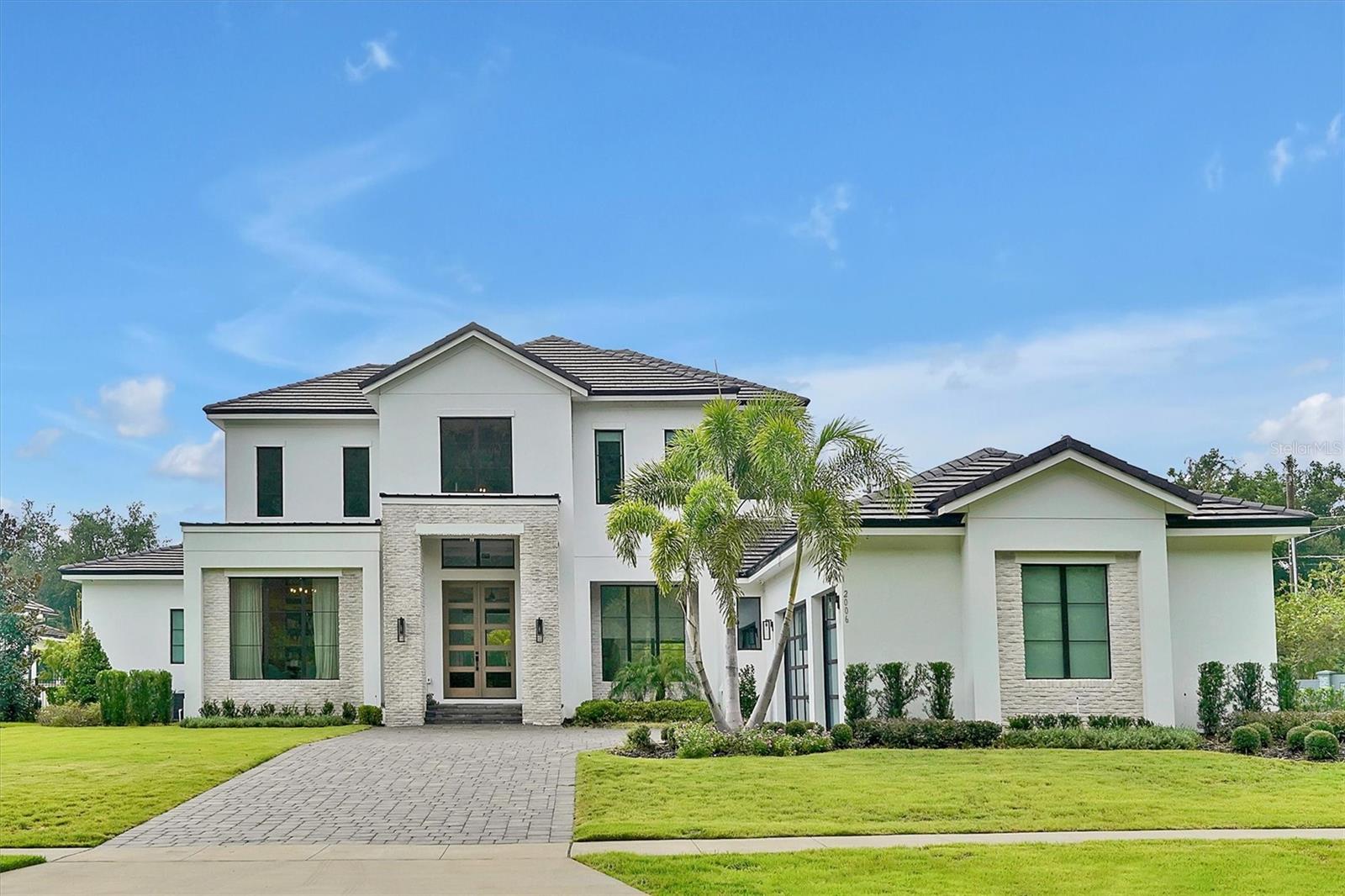 Welcome to the exquisite 2006 Bellamere Ct, a masterpiece crafted by Element Home Builders. Discover the epitome of luxury living with their renowned "Vineland" plan, showcasing unparalleled craftsmanship and meticulous attention to detail. This transitional gem offers a 5 bedroom, 4½ bathroom layout adorned with lofty ceilings, an array of pocket sliding glass doors, and thoughtfully designed living spaces that seamlessly flow. 
The residence offers 2 flex spaces turned to offices with wonderful built ins with lighting that gives it an extra sophisticated atmosphere. The first floor master bedroom features a huge bathroom with a walk-in closet with built ins and a central island for your jewelry and extra room.
Indulge in culinary delights within the open kitchen, adorned with a grand waterfall countertop island, a sophisticated dining area, and an inviting great room. A bespoke office space with built-ins and a refined entertainment haven await, featuring a game room complemented by a snack bar and a discreet mini-fridge.
Every step graced by engineered hardwood floors, and every glance met with elegance through vinyl double pane windows and decorative glass entry doors. Modern luxuries abound, from tank-less hot water heaters to spray foam insulation. The paver driveway and insulated 3 car garage doors culminate in an epoxy-finished garage floor, all seamlessly integrated.
AC zones cater to your comfort, while detailed ceilings, quartz countertops, a walk-in pantry, and generous built-in closets define sophistication. Top-tier Thermador appliances and custom shelving enhance functionality, while seamless glass shower enclosures and designer LED lighting add finesse. 
Step into the outdoor oasis, where a captivating pool and spa await. The summer kitchen, graced with Marine grade cabinetry, sink, and grill, beckons for alfresco gatherings on the travertine pool deck. A vast covered living space ensures year-round enjoyment.
Set upon a sprawling oversized .65-acre parcel, this home boasts a premium landscape package and lush zoysia grass. Nestled within an exclusive community of just 12 estates, each site over half an acre, this residence is a testament to Windermere's untouched splendor. Majestic pine and oak trees frame this locale, with elevations offering panoramic views across eleven interconnecting lakes.
Windermere, a haven of natural beauty, is adorned with crystal-clear lakes and pristine panoramas. Nestled amidst this serenity, you remain well-connected to A-rated schools, verdant parks, a vibrant farmer's market, renowned golf courses, delectable dining, and world-class attractions including Disney World and Universal Studios. The house has a paid off solar panel.