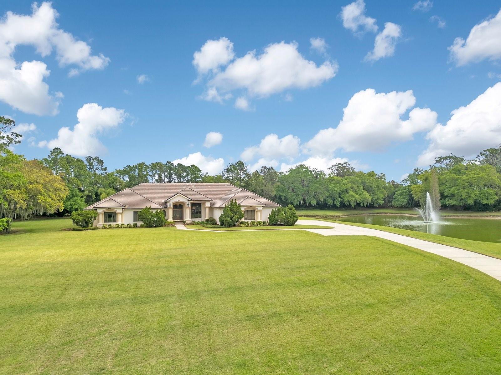 Priced under appraised value. Situated on nearly six contiguous acres within the Lakeland city limits, this expansive estate offers a rare combination of significant acreage and uncompromising security. The entire property is fully gated, providing an elite level of privacy and peace of mind that is increasingly difficult to find in the heart of central Lakeland’s bustling community. Originally built in 1990 by a premier local custom builder to the exacting standards of the original owners, the residence has been meticulously maintained to meet the highest expectations. With nearly 7,000 square feet of living area, the home is designed for effortless functionality, with the vast majority of the living space conveniently located on a single level.

The interior is a study in craftsmanship, featuring five generous bedrooms, five and a half bathrooms, and a dedicated executive office. An expansive upstairs bonus room, complete with an ensuite bathroom, offers the flexibility to serve as a high-end media suite or a sixth bedroom with the simple addition of a closet. Throughout the residence, one finds an extensive array of bespoke built-in features and voluminous storage solutions that reflect a level of quality and permanence seldom seen in modern construction.

The outdoor living space is a true sanctuary, centered around a resort-caliber pool area featuring a covered bar and a full exterior bathroom. These amenities overlook professionally landscaped grounds that have been intentionally designed for maximum seclusion. A defining hallmark of this six-acre retreat is its privately owned lake, which includes a beautiful architectural fountain that creates a serene and picturesque backdrop for the entire estate. For the automotive enthusiast or those with substantial recreational equipment, the oversized three-bay garage is deep enough to accommodate a boat, larger vehicles, or up to six smaller cars parked in tandem, supplemented by a dedicated parking pad for guests.

Finding a fully enclosed, six-acre tract with a private lake in central Lakeland is an extraordinary anomaly. This property offers the quietude and scale of a rural manor while remaining mere minutes from the city’s highly desired dining, medical facilities, and major transportation corridors. In one of Florida’s fastest-growing communities, this estate represents a unique opportunity to acquire a legacy land holding that perfectly balances absolute privacy with the accessibility of a prime central location.