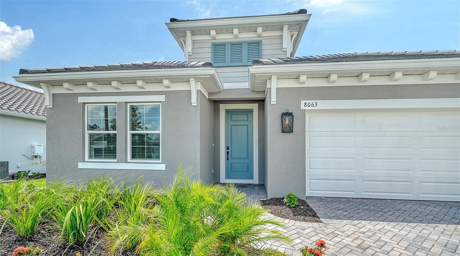 This thoughtfully designed single-family home offers 2,332 square feet of living space and features numerous upgraded finishes throughout. Wood-look tile flooring extends through the main living areas and primary suite, while a recessed tray ceiling enhances the spacious great room. The primary suite includes dual walk-in closets for ample storage. The kitchen is appointed with 42-inch soft-close cabinetry, quartz countertops, and matte black plumbing fixtures and hardware. A pocket sliding glass door creates a seamless transition to the outdoor living space, making it ideal for indoor/outdoor entertaining. Additional features include a tankless water heater and impact-resistant glass throughout the home.