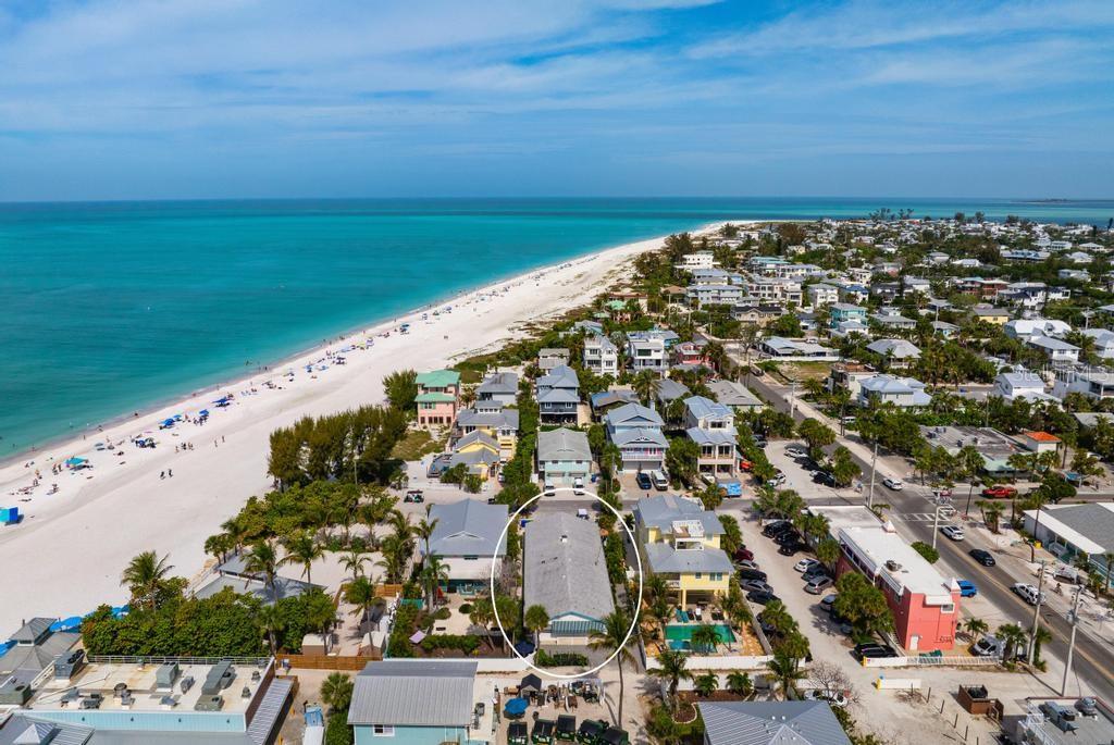 For Investors looking to purchase property on the desirable north end of the Anna Maria Island, this unique and rare 4-unit apartment building is an exceptional investment opportunity.  Welcome to Gulf Queen Apartments just 50 feet from the sugary sandy beaches of Anna Maria Island. Situated on nearly 7,400 sq ft lot, the property also presents future redevelopment potential—offering investors the flexibility to build new in this prime coastal location.  This turnkey furnished, ground level 4-plex has two apartments with two bedrooms and one bathroom; and two apartments with one bedroom and one bath.  Gulf Queen Apartments offers immediate income potential in one of Florida’s most sought-after beach markets.  The units showcase polished terrazzo flooring, open-concept living and kitchen areas, and tasteful coastal décor. Recent upgrades include renovated kitchens with granite countertops, updated bathrooms, and new furnishings throughout—creating an inviting, guest-ready environment. The 2-bedroom units comfortably accommodate up to four guests, making the property ideal for group bookings such as family vacations, reunions, or wedding parties. Anna Maria is known as a desirable wedding destination. The entire building can be rented out to accommodate wedding guests or other family gathering venues, or each unit can be rented individually. The property also has two golf cart charging stations to accommodate guests who want to tour the island in their rented golf cart. The property is located next door to the Sand Bar Restaurant which hosts many wedding guests from around the world each year. The property is also located on famous Pine Avenue, a street that runs from Tampa Bay to the Gulf of Mexico.  The property's 107 Pine Avenue address is walkable to numerous shops and restaurants that stretch from the Bay to the Gulf.  The location is unmatched—just steps to the beach, as well as the vibrant shops and dining along Pine Avenue, and convenient access to the free island trolley. Guests can easily stroll or bike to Bean Point, or enjoy nearby favorites like The Waterfront Restaurant and The Sandbar Restaurant.  Whether you’re seeking a vacation rental portfolio or a redevelopment opportunity in a premier beach destination, Gulf Queen Apartments delivers value, location, and income potential. Vacation Rental bookings available upon request.  Call for a private viewing of this unique property today.