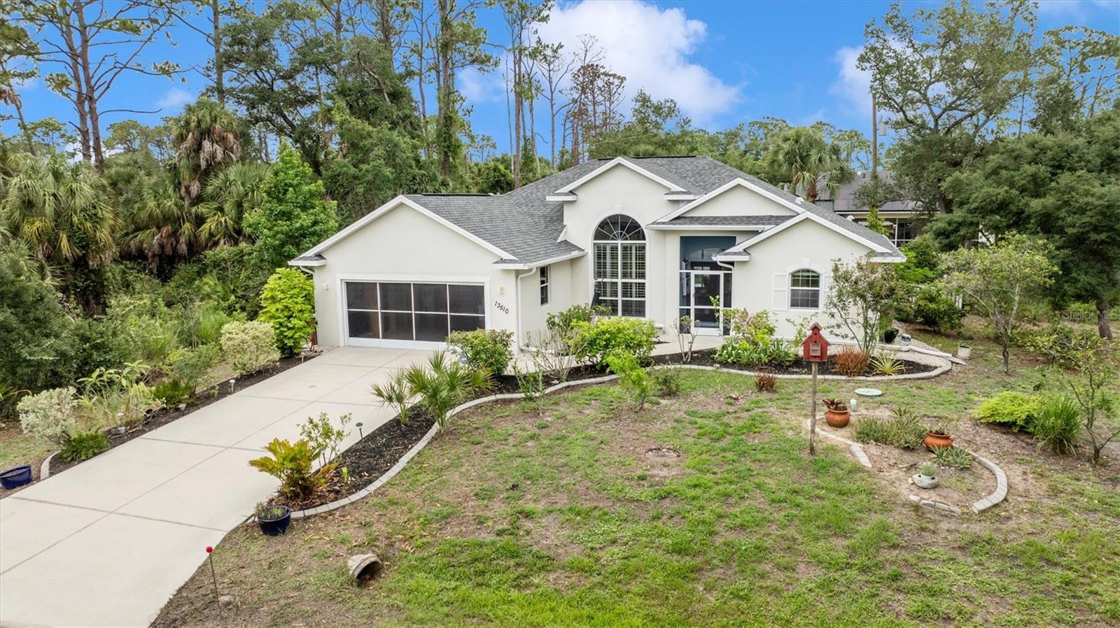 MOVE IN READY ON THE NORTH PORT LINE. This beautifully maintained 1845 square foot home offers 3 bedrooms plus office or den, and 2.5 bathrooms on a quiet street in NW Port Charlotte. Built in 2007 with durable concrete block and stucco construction, the home has been lightly lived in and lovingly cared for by seasonal owners for the past 15 years. Every detail reflects pride of ownership and thoughtful maintenance, making this property truly move in ready. Major updates have already been completed including a brand new roof installed in 2025 and a new air conditioning system installed in 2021, providing peace of mind for years to come along with potential savings on homeowners insurance. Fresh interior paint, new luxury vinyl plank flooring in the primary bedroom suite, and a professional deep cleaning add to the pristine condition of the home. Natural light fills the living spaces through a stunning 12 foot picture window accented with plantation shutters. Three sliding glass doors open directly onto the screened lanai creating seamless indoor outdoor living and bringing the peaceful outdoor setting into the home. A separate family room provides additional living space for relaxing or entertaining. The kitchen offers a bright breakfast nook overlooking the lanai, plantation shutters, a spacious pantry, and a brand new dishwasher. The split bedroom floor plan provides privacy and functionality with a spacious primary suite featuring an ensuite bathroom and a 50 square foot walk in closet, making it ideal for full time living or as a seasonal Florida retreat. The screened lanai includes an outdoor shower and convenient half bath, allowing the outdoor space to function as a true extension of the home. The attached garage provides more than just parking with an epoxy coated floor and custom built cedar closet that create exceptional storage and workspace rarely found at this price point. The property is serviced by a private well with a whole house water treatment system and under sink reverse osmosis for excellent cooking and drinking water quality without the expense of a monthly water bill. Irrigation uses the same well, helping maintain the mature and drought tolerant landscaping at minimal cost. The grounds feature citrus, banana, and lychee trees along with native Dahoon hollies that add natural Florida beauty and charm. Conveniently located just one mile from US 41 with easy access to I 75, the home is close to shopping, dining, medical facilities, and the beaches of Boca Grande and Englewood. There is no HOA and two adjoining vacant lots are also available for separate purchase. Come prepared to be impressed. The care and quality waiting inside this home go well beyond what the price tag suggests.