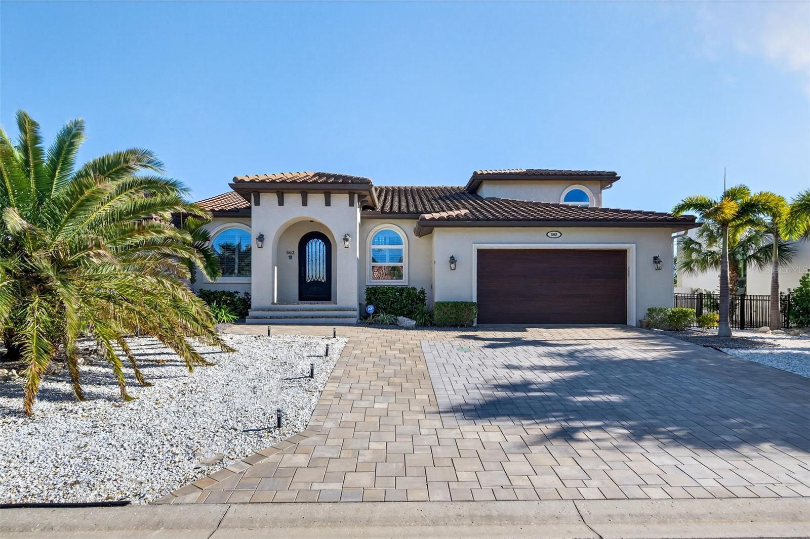 One or more photo(s) has been virtually staged. A rare opportunity to own a single-family waterfront home with 100 feet of canal frontage and direct access to Sarasota Bay. Located in Country Club Shores on the desirable southern end of Longboat Key, 562 Ranger Lane offers 4 bedrooms, 3 full baths, and approximately 3,149 square feet of living space designed for relaxed coastal living. The property features a sunny southern rear exposure overlooking the canal, with a north-facing street frontage, providing balanced natural light throughout the day.
The home underwent a comprehensive renovation in 2018, including a tile roof, paver driveway, two Trane A/C units, tankless water heater, updated sprinkler system, railings, pool equipment, and a Pebble Tec refinished pool positioned to maximize the southern exposure.
The interior features an open great-room layout with 16-foot ceilings, porcelain tile flooring throughout, plantation shutters, LED lighting, and a spacious kitchen with Starmark solid-wood soft-close cabinetry, Cambria quartz countertops, and stainless-steel appliances. An 8-foot arched iron front door introduces abundant natural light and an open, functional floor plan.
The current configuration includes an upper-level primary suite with solid oak flooring, walk-in closets, and a well-appointed bath, while the first level offers three large bedrooms, including an office with custom built-ins, and two full baths with handcrafted cabinetry, quartz countertops, and glass-enclosed showers. The flexible layout provides the opportunity to create a first-floor primary suite to suit individual lifestyle needs.
Boating amenities include a new seawall, a 70-foot private Trex dock with 50-amp shore power, and a recently serviced 10,000-pound boat lift. Outdoor living is enhanced by a covered lanai and a two-level travertine deck ideal for entertaining and enjoying the canal setting. Residents enjoy access to a private deeded beach on the Gulf of Mexico and proximity to Longboat Key Club golf, dining, and shopping at St. Armands Circle, with downtown Sarasota’s cultural arts and dining scene just minutes away. Schedule a private showing to experience this waterfront home, its flexible living options, and direct access to Sarasota Bay