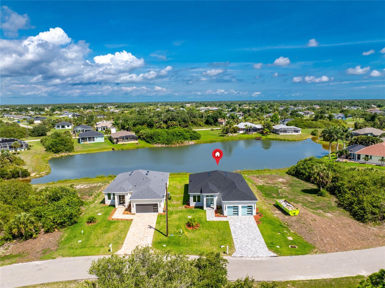 Under Construction. Modern Lakefront 2026 Completed Home with Contemporary Architecture and Water Views in Rotonda Lakes! This newly completed 3 bedroom, 2.5 bathroom home overlooks a freshwater lake, providing beautiful water views from both the interior living spaces and the screened lanai. From the moment you arrive, the paver driveway, modern architecture, attractive landscaping, and striking light blue front entry and garage doors create exceptional curb appeal. Inside, the open-concept floor plan is enhanced by luxury vinyl plank flooring throughout, tray ceilings, abundant natural light, custom frosted glass closet doors in all bedrooms, and contemporary finishes that create a clean, modern aesthetic. The kitchen serves as the heart of the home with quartz countertops, a designer sink, custom flat-panel soft-close cabinetry, stainless steel appliances, an oversized island with waterfall countertops and breakfast bar seating, and sliding glass doors leading to the lanai. Adjacent to the kitchen is a spacious dining area that easily accommodates formal gatherings or everyday meals. The split-bedroom design provides privacy for both owners and guests. The primary suite features dual walk-in closets and a beautifully appointed ensuite bathroom with dual vessel sinks, quartz countertops, a soaking tub, and a walk-in shower with rain shower head. Guest bedrooms are situated on the opposite side of the home, while the guest bathroom offers matching upscale finishes including a vessel sink, quartz countertops, soft-close cabinetry, and a walk-in shower with rain shower head. An additional half bathroom provides convenience for visitors. The interior laundry room includes a utility sink and direct access to the garage, while the attached garage features epoxy flooring and additional storage space. Step outside to the covered paver lanai and enjoy peaceful lake views while embracing the outdoor Florida lifestyle. The lanai is already pre-plumbed and pre-wired for a future outdoor kitchen, providing an excellent opportunity to create a custom outdoor entertaining space designed around the waterfront setting. Located at 203 Redwood Road in Rotonda Lakes, this home offers convenient access to golf courses, boating, fishing, dining, shopping, historic Dearborn Street, and the Gulf beaches of Manasota Key and Boca Grande. Whether you are searching for a full-time residence, seasonal retreat, or investment property, this brand-new home delivers modern style, quality construction, and the Southwest Florida lifestyle so many buyers seek.