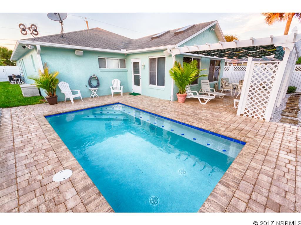 One of the best New Smyrna Central Beachside Homes. Just across the street from the beach. A beautiful 3/2 with 1800 sq. feet with  heated pool, lush landscaping. Fully furnished with audio and video systems.  A 2 car garage, alarm and cctv system as well as new AC and Appliances.  Home is very popular, walking distance to Flagler and has great investment potential and is within the 7 day rental zoning border.  Fully turn key. Rental History. New Lifetime Roof, Solar Attic Fans, Kohler Full House Generator, ;Water: City