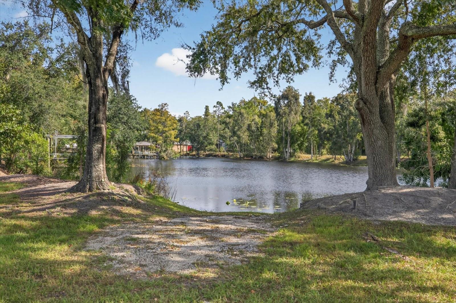 Don’t miss this RARE opportunity to own the last buildable lot (builder information available upon request) in The Enclave at Lake Padgett, an exclusive 20-site, deed-restricted, gated community located on the cove of Lake Padgett. Lake Padgett is a 200-acre private lake featuring a ski course with ramps and a slalom run. The lake is spring-fed and allows boating, tubing, skiing, and jet skis. It’s also known for excellent fishing with trophy bass and bluegill.
Enjoy a private and secluded waterfront setting surrounded by beautiful oak and cypress trees, right in the heart of Land O’ Lakes. Build your custom dream home here minimum 3,000 sq ft under air, with most homes in the neighborhood around 4,000 sq ft.
This 0.40-acre lot offers plenty of space for a large home and pool, with 145 ft of road frontage, 185 ft depth, and 62 ft of waterfront on the cove. The property includes a natural boat ramp, and docks with lifts are permitted. A 25 ft conservation line runs from the shoreline inward.
Conveniently located near Tampa’s best shopping, theme parks, sporting and concert venues, and world class beaches. Easy access to I-75, I-4, the Veterans Expressway, and I-275, and only 25 minutes to Tampa International Airport.
This is an exceptional piece of property. Build your own Florida Oasis. Home Featured in Photo 2 is an example of a home that could be built on this lot. The builder of this home lives in the neighbhorhood and has built several of the houses.