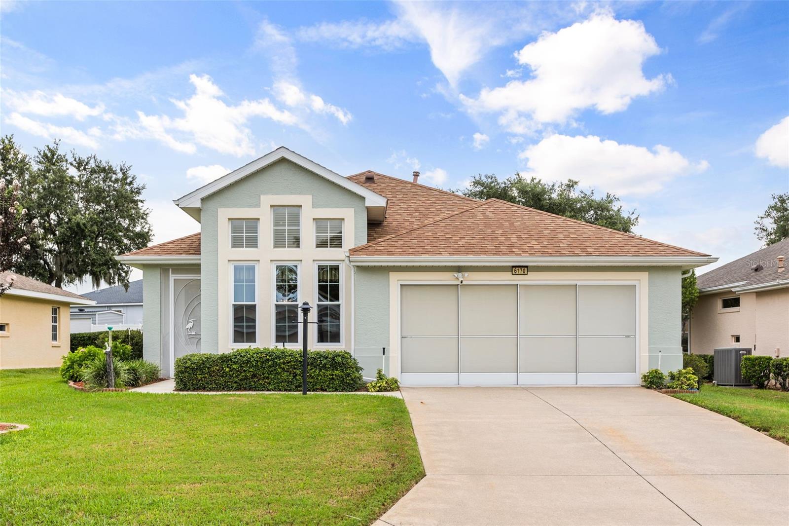 Welcome to this beautifully maintained 3-bedroom, 2-bathroom home nestled within the sought-after gated 55+ community of Royal Harbor, perfectly situated along the scenic Harris Chain of Lakes. Thoughtfully updated over the years, this home offers peace of mind with a new A/C system (2025), roof (2020), gas water heater (2024), shades and shutters (2021), plus updated windows, enclosed front entry, and gutters.


Designed for both everyday living and entertaining, you'll enjoy multiple outdoor spaces, including a covered screened patio and an open-air patio that's perfect for grilling, relaxing, or gathering with family and friends. Inside, the open-concept kitchen and dining area flow seamlessly into the spacious living room, complete with additional bar seating for casual dining or entertaining.


The private primary suite is a comfortable retreat featuring direct patio access, a generous walk-in closet, and an ensuite bathroom with dual vanities and a large walk-in shower. Two additional guest bedrooms offer ample closet space, ceiling fans, and easy access to the nearby guest bathroom.


The oversized driveway provides plenty of parking, while the screened two-car garage offers additional functionality and comfort.
Beyond the home, Royal Harbor offers an exceptional resort-style lifestyle with outstanding amenities, including a clubhouse, heated pool and spa, pickleball and tennis courts, shuffleboard, walking and biking trails, a private dock and fishing pier, numerous clubs and social activities, breathtaking sunsets at the community lighthouse, and dedicated RV and boat storage.


All that's left to do is move in and start enjoying everything this incredible lakefront community has to offer.