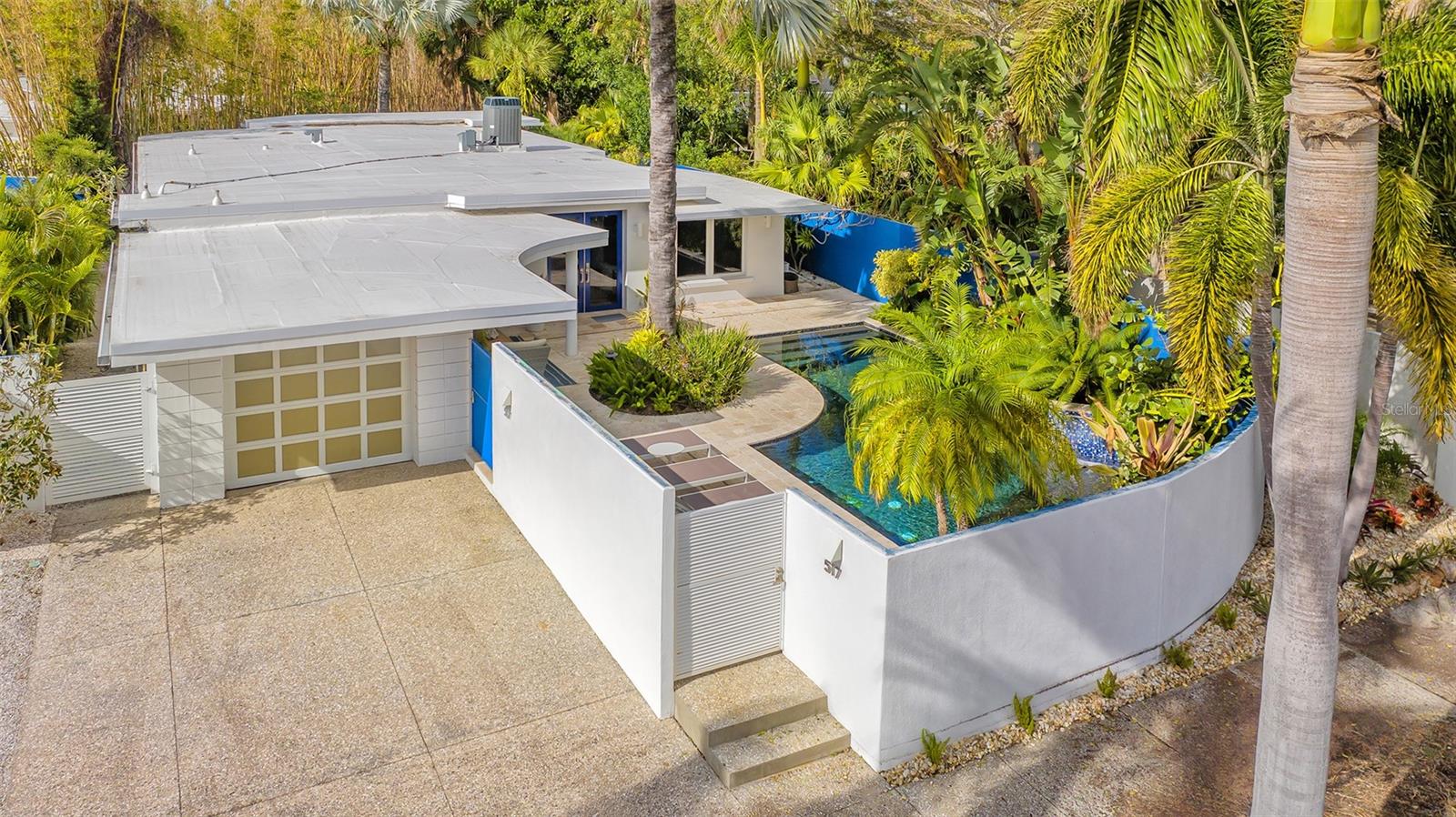 Welcome to your fully furnished dream home, where modern luxury meets natural serenity! Nestled just one block off the vibrant St. Armands Circle and a short bike ride to the pristine shores of Lido Beach, this impeccably remodeled mid-century modern residence is a coastal haven. Step into timeless elegance on the terrazzo floors that grace the home, featuring 2 living areas, a large dining room for entertaining and 4 bedrooms, with ensuite bathrooms, for the ultimate in comfort and privacy. Surrounded by lush foliage, the large travertine patio, adorned with a refreshing pool, offers a private oasis for you to unwind in the Florida sun. Privacy walls enhance the sense of tranquility, creating an intimate retreat amidst the greenery. As night falls, the enchanting outdoor lighting illuminates the landscape, setting a magical ambiance for evening relaxation.
Proximity to St. Armands Circle means endless dining, shopping, and entertainment options, while a short bike ride takes you to the sandy shores of Lido Beach. Enjoy peace of mind with a brand-new roof installed in 2023 and relish the modern convenience of all-new appliances and Hurricane impact windows, doors and sliders.This mid-century modern gem, surrounded by lush foliage and privacy walls, is not just a home; it's a lifestyle waiting for you to call it your own.