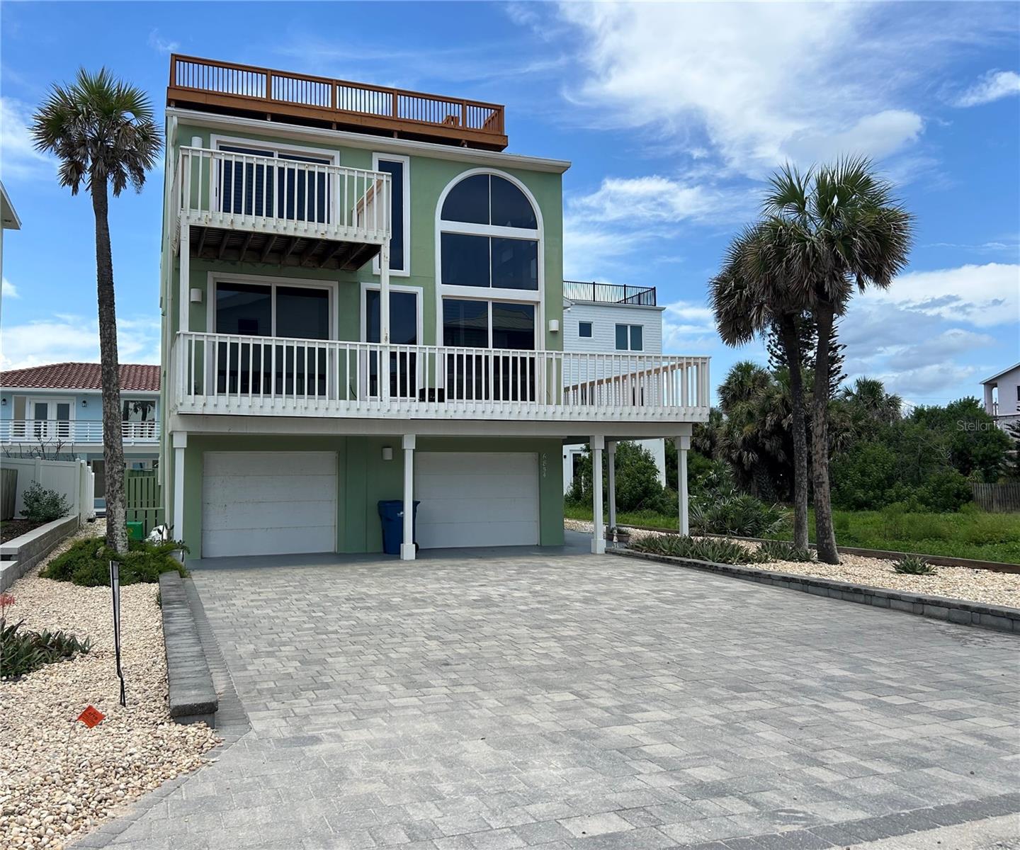 Stunning 3 story coastal home designed to maximize light, space & breathtaking water views of the ocean sunrises & the river sunsets! Spacious 3BR,3BA residence offers an open & inviting floor plan with 2,748 sq.ft of living space. The first level features a fantastic game room or mancave, complete with billiard table, poker table, large granite counter bar with stools, small refrigerator & full bath with a built-in sauna. Also featured is an attractive wood tongue & groove ceiling & a fantastic sound system with built in speakers. The highlight of the home is its spectacular outdoor living spaces! Entertaining is easy on the beautifully pavered back patio complete with a palm roof tiki bar & outdoor shower. An oversized 2 car garage has Maytag washer & dryer, an extra refrigerator & provides ample room for vehicles, beach gear, fishing gear & additional storage. The main living level on the 2nd floor features a bright, open concept great room with 2 story soaring ceilings, arched windows & expansive floor-to-ceiling windows & doors that open to a large wrap around balcony. This balcony provides the perfect setting for outdoor dining, entertaining or simply relaxing while feeling the breeze and hearing the waves! The gourmet kitchen is equipped with granite countertops, beautiful white cabinets with pull out drawers, premium appliances, lazy susan, pantry & cabinets with special lighting. There are two spacious bedrooms on this 2nd level with a full bathroom & stylish tiled step in shower. The primary suite is on the 3rd floor & includes a spa-inspired bathroom with a garden tub, walk-in shower, dual vanities & a spacious walk-in closet. Enjoy the private ocean view balcony that extends off the master bedroom. Also featured on this level is a versatile loft, media room, office or 4th bedroom for overflow guests. From this loft is access to the 4th & 5th floor ocean view deck, the tallest deck in Bethune Beach! Stunning views of both the ocean and the river are yours to enjoy from this large 31x10 deck! Watch the rocket launches & spectacular sunrises & sunsets from the comfort of your home. Situated just 7 lots away from a public beach walkway for access to the car free pristine beach! Only 1 block from JB's Fish Camp and 1 mile from the famous Cape Canaveral National Park. Just a few miles to world class restaurants & bistros, art shows, wine tastings, souvenir shops, car shows & museums. Buy your piece of paradise today!