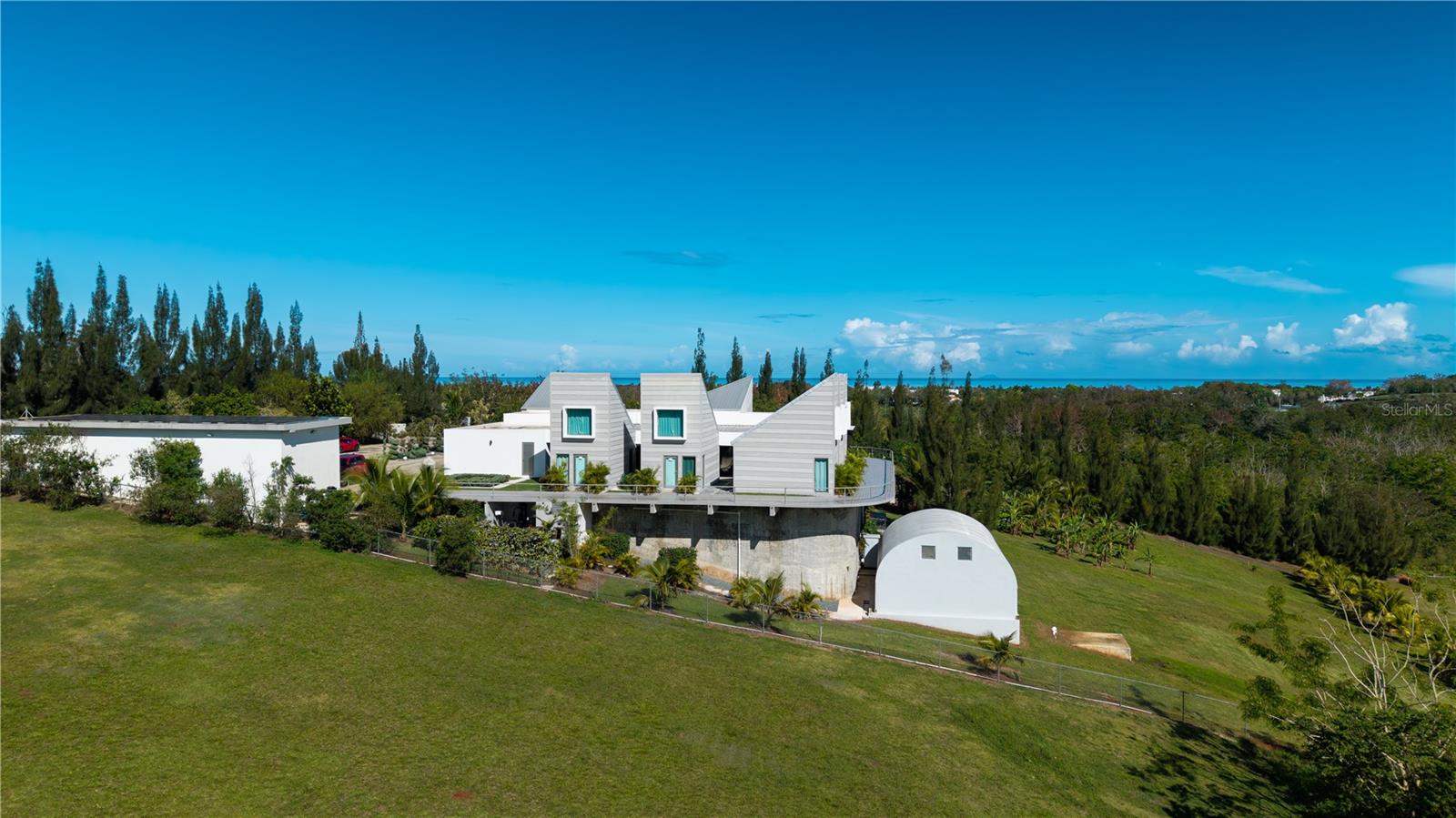 An extraordinary architectural estate set on expansive grounds in the highly sought-after Cabo Rojo region, offering a rare combination of privacy, scale, and modern design within one of Puerto Rico’s fastest-growing luxury and investment corridors.

This one-of-a-kind residence is defined by its striking contemporary architecture, featuring clean geometric lines, dramatic rooflines, and expansive glass elements that frame breathtaking views of the surrounding landscape. Positioned on a generous lot, the property offers exceptional privacy while maintaining convenient access to the area’s most desirable coastal destinations.

Inside, the home showcases soaring ceilings, open-concept living spaces, and an abundance of natural light, creating a seamless connection between interior elegance and outdoor living. High-end finishes, refined materials, and thoughtfully designed spaces elevate the overall living experience to a true luxury standard.

The primary suite serves as a private retreat with grand proportions, complemented by a spa-inspired bathroom designed with premium finishes. Throughout the residence, every detail reflects quality, comfort, and sophistication.

This exceptional property features four independent suites, each with its own private entrance, offering unmatched flexibility for multi-generational living, guest accommodations, or income-producing opportunities such as luxury short-term rentals or boutique hospitality concepts.

Designed for a resort-style lifestyle, the estate includes a private sauna, a fully equipped gym, and a jacuzzi, providing a complete wellness experience within the privacy of your own home. Expansive covered terraces, outdoor entertaining areas, and thoughtfully designed social spaces create the perfect setting for hosting or relaxing in a serene environment.

The exterior of the property is equally impressive, featuring extensive open land, landscaped areas, and a commanding presence enhanced by its elevated positioning. The layout allows for future expansion, additional structures, or customized development, making it highly attractive for investors or those seeking to create a private compound.

Additional features include energy-efficient systems such as solar panels, gated access, and enhanced security elements, ensuring both sustainability and peace of mind.

Ideally located just minutes from Combate Beach, Boquerón, Las Salinas, and the iconic Cabo Rojo Lighthouse, this property offers the perfect balance between tranquility and accessibility in a rapidly appreciating market.

This is a rare opportunity to acquire a truly distinctive estate that combines luxury living, architectural design, and strong investment potential.

Private showings by appointment only. Proof of funds or pre-qualification may be required prior to scheduling.