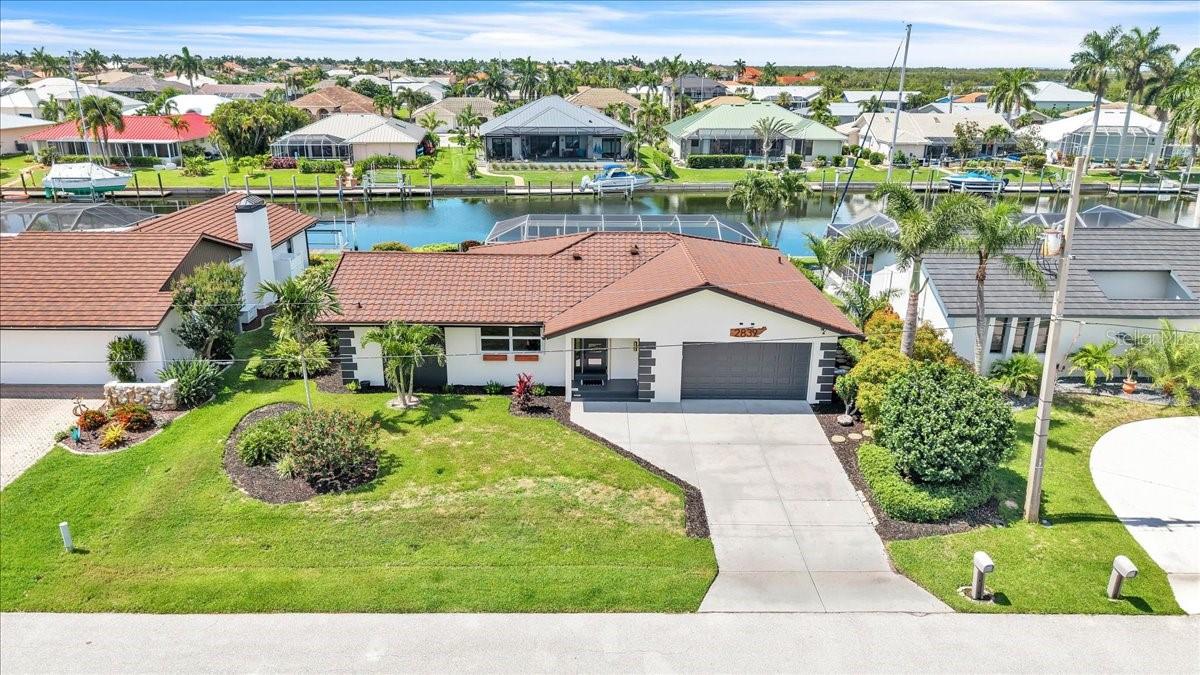 Boaters, fishermen, and water enthusiasts—take note! Welcome to your slice of Florida waterfront living, where comfort, style, and sunshine come together effortlessly. This sailboat waterfront pool home is just minutes to open water access of Charlotte Harbor and delivers the true Florida boating lifestyle. Located in the highly desirable waterfront community of Punta Gorda Isles, this beautifully maintained residence offers modern updates throughout and a warm, inviting exterior featuring manicured tropical landscaping, and a spacious driveway leading to a two-car garage. Nestled along a serene canal, the property offers direct water access and stunning backyard views framed by swaying palm trees. The surrounding neighborhood showcases well-kept homes and a peaceful atmosphere, perfect for relaxing or entertaining. Inside, you’ll find a bright and open floor plan with a combined living and dining area designed for flexibility and easy living. Brand new luxury vinyl flooring throughout.  The updated kitchen is a standout with quartz countertops, tile backsplash, stainless steel appliances, pantry, and a casual dining area with sliders that open directly to the pool and capture beautiful waterway views. A built-in buffet with unique wine storage adds both style and functionality, making entertaining effortless. Both primary suites feature walk-in closets and fully updated en suite bathrooms, offering comfort and privacy for owners and guests alike. Extensive updates throughout the home provide peace of mind, including new stone-coated steel roof (2023), updated electrical panel, replumbed water lines with a centralized PEX manifold system, newer hot water heater, newer AC system with UV light (2020), and a whole-house generator. Additional improvements include storm shutters (except back), irrigation system, newer pool cage, resurfaced pool with electric heat, and public water and sewer. Step outside to your private waterfront oasis where the heated pool overlooks the tranquil canal. A brick-paved walkway leads to a concrete dock with water and electric—ideal for boating, fishing, and enjoying the water lifestyle. The concrete seawall is maintained by the City of Punta Gorda for added convenience and peace of mind. Ideally located near beaches, golf courses, dining, and shopping, this home also provides easy access to parks, walking and biking trails, picnic areas, and boat ramps leading to Charlotte Harbor, the Peace and Myakka Rivers, and the Gulf of Mexico. Just minutes to historic downtown Punta Gorda and Fishermen’s Village with its charming shops and waterfront dining. This is a quiet, well-kept waterfront community with all conveniences nearby offering the best of Florida living. Move-in ready with extensive updates throughout, this home is the perfect blend of coastal charm, comfort, and waterfront lifestyle.
**PLEASE ENJOY THE 3D INTERACTIVE VIRTUAL TOUR ASSOCIATED WITH THIS LISTING**