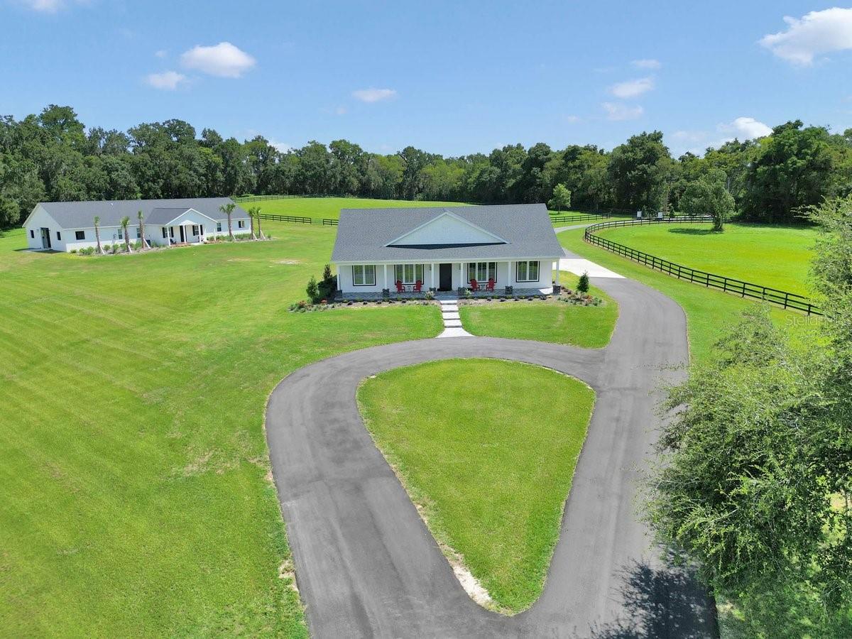 Under contract-accepting backup offers. Exceptional 34-acre equestrian estate. Discover this new, turnkey horse property on 33.53 acres of high and dry land, thoughtfully designed for horse and rider. Offered as two separate parcels, this estate combines luxury living with premium equestrian amenities. The custom four-bedroom, 2.5-bath home features elegant porcelain tile throughout, brushed gold tone fixtures, soaring ceilings, quartz countertops and a spacious front porch with paver flooring, ideal for relaxing and taking in the views. Two lighted electric gated entrances plus a third separate drive offer ideal access for trailer parking or client ship-ins. Equestrians will appreciate the 10-stall block barn featuring a 400-square-foot studio apartment with kitchen, full bath, laundry with abundant cabinetry, feed room, tack room, hot/cold wash stall and a breezy 16-foot-wide center aisle. Each 12-by-12-foot matted stall includes lights and fans for optimal comfort. Water is run to all six paddocks and two large fields, all conveniently near the barn. Enjoy a 4/10-mile grass uphill gallop, well-established pastures and ample room to add a cross-country course, arenas or additional structures. Extensive landscaping surrounds the home, barn and gated entries, all with irrigation. Don't miss this extremely rare opportunity to own a new equestrian estate.