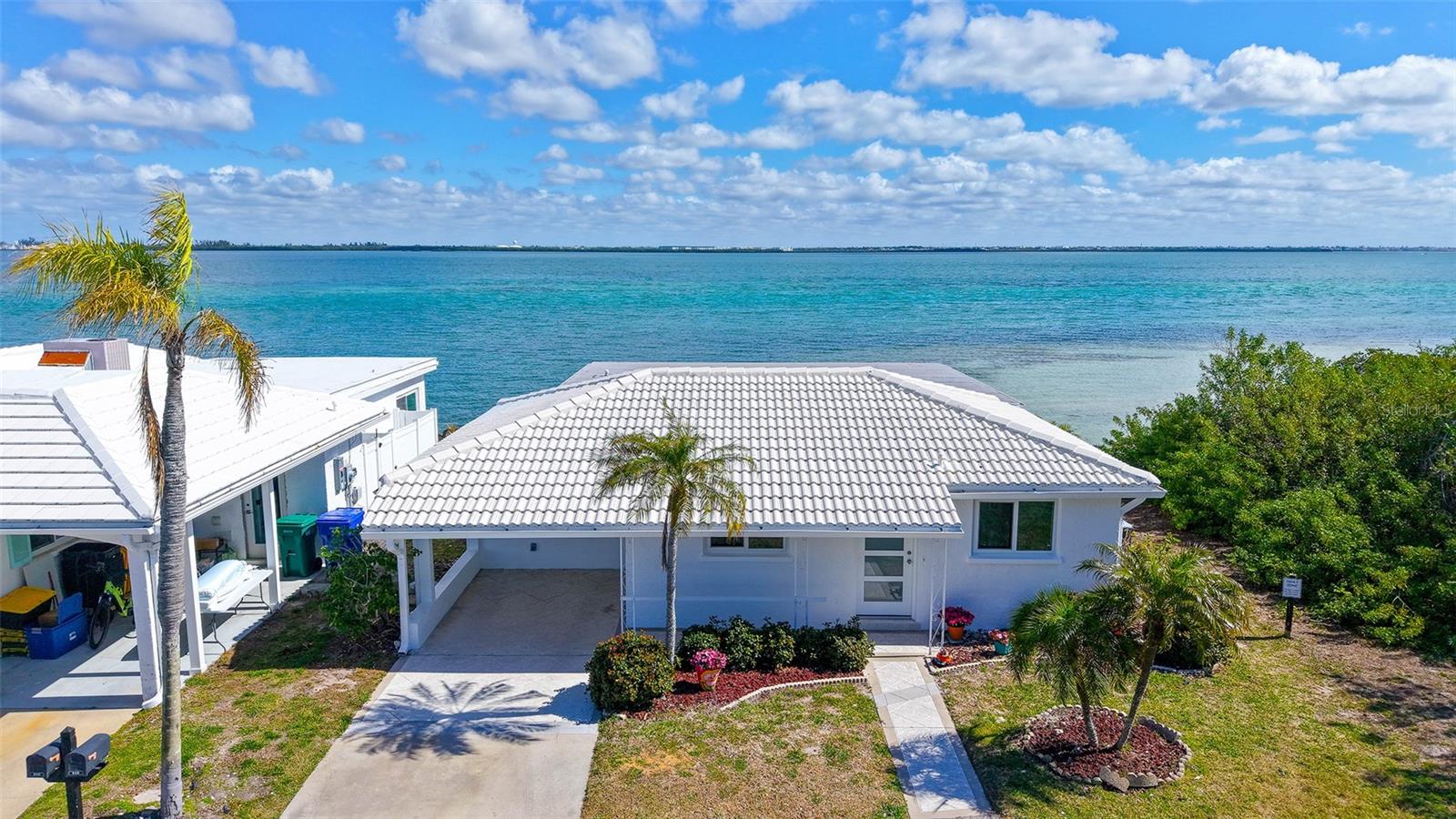 Stunning full bay views as you enter this jaw-dropping magnificent, completely custom renovated stand-alone villa on Sarasota Bay. Professionally designed starting with an 18-by-11-foot gourmet kitchen. With 10-12-foot wood beam ceilings, a beautiful 12-foot quartz island that seats 10-plus people, solid wood cabinetry, Café’ brand double oven, refrigerator with two additional drawers, stainless steel appliance, huge undermount sink, glass backsplash, separate wet bar and more. The 2-by4-foot white porcelain rectangular tile flows seamlessly from room to room with water views that entertain you every moment of every day. With the Intracoastal Waterway just beyond the brick paver back patio, the wildlife is abundant, more than you can imagine, with morning sunrises that softly greet you as you awaken to a true slice of paradise. The entire glass-enclosed 23-by-12-foot lanai brings so much light, brightness and cheerfulness that it makes your heart smile. The end unit offers privacy and protection with lush green mangroves creating a protected area plus easy access for entering the water, going for a swim, fishing or kayaking. Back to the renovations, the main bedroom en suite offers privacy with upscale bath appointments, a double sink, and large designer shower. The enclosed laundry area right off the bedroom was carefully crafted with a walk-in closet, extra storage room and a rare whole-house water purification system. Not to mention all hurricane windows and doors throughout with additional footings, foam support and steel beams under the sliding doors to ensure structural integrity and peace of mind. All appliances are 2025, LG Thin Q washer and dryer, Café kitchen appliances, tankless hot water tank, custom fan and lights, all new plumbing and electrical as the home was taken down to the studs. PVC sewer lines completely replaced all cast iron pipes. New tile roof in 2025. There is nothing to do except move in and relax. You will not be disappointed. All FEMA regulations have been completed, including inspections. Vibrant waterfront 55-plus community with 40-slip marina and deeded beach access to gorgeous beaches of Longboat Key. Close to restaurants, shops, renowned St. Armands Circle, plus 30 minutes to Sarasota International Airport. Take a look.