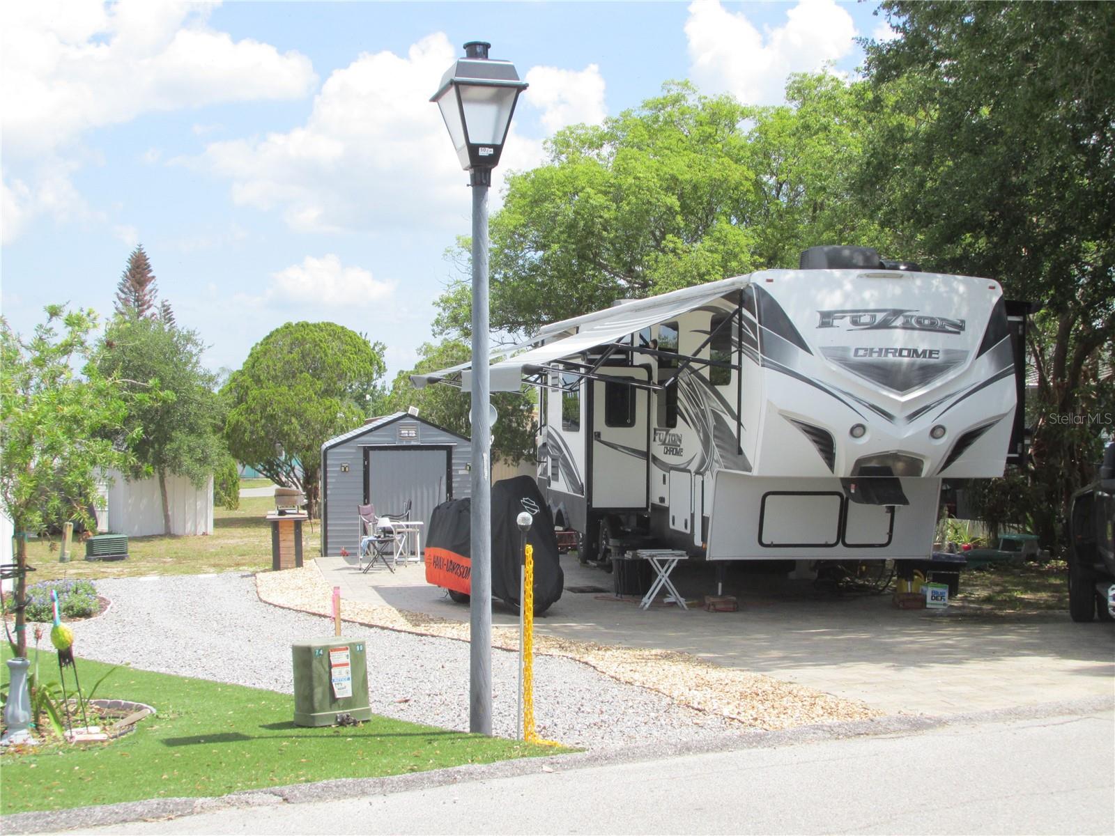 This shaded RV lot is located in Saddlebag Lake Resort, a pet friendly 55+ gated community.  Lot dimensions are approximately 46 x 83. The pavered parking pad will easily accommodate up to a 45 ft. RV, with plenty of room for vehicle parking. Well manicured and hardscaped,  the lot is situated at an intersection so it's easy to back into.  The site has full hookup with 20/30/50 amp service, water, sewer and communication connections (Internet and Landline phone) at the pedestal.  Shed has solar powered lighting and solar exhaust fans.  If you're ready to get off the road and park your RV where you can enjoy lots of amenities, you've found the right place.  Choose from swimming in the sparkling community pool, relaxing in the hot tub, or playing a game of pickle ball.  Of course, you might want to practice your swing at the driving range, play a friendly game of pool in the rec room, or work out in the fitness center.  You can participate in planned activities in the clubhouse, go boating or fishing on Saddlebag Lake, or take your furry family members to the dog park so they can run around to their heart's content.  The low quarterly HOA covers it all - plus your water, sewer and trash pick-up.  Call now to schedule your private tour!