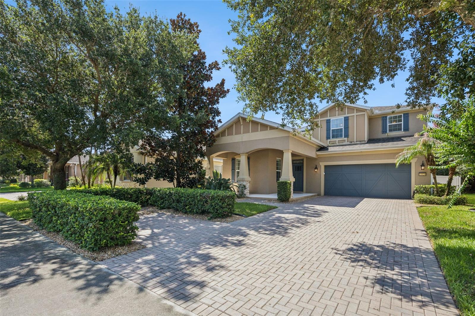 Situated on a distinguished homesite in one of Windermere's most sought after locations, 13328 Overstreet Road impresses right when you pull into the oversized 6+ CAR PAVER DRIVWAY with parking for up to six vehicles. If any of those vehicles are electric, you can charge them using the installed TESLA CAR CHARGER and save $$ on the electric bill with the PAID-OFF SOLAR PANELS. This home defines exceptional value and modern efficiency. At the heart of the home, the GOURMET KITCHEN is an entertainer's dream, with not one, but two center islands, ample solid WOOD CABINETS with crown molding, granite counters, and a tile backsplash. A stainless steel appliance package complements these features. A spacious dining area, family room, a mini mudroom off the garage, and a multipurpose space with additional cabinetry perfect for a small office, coffee bar, or wine bar. If you are looking for some multigenerational space, take advantage of the downstairs ensuite, which includes built-in closet organizers, a new vanity and toilet and a walk in shower. There is no carpet; the entire first floor has ceramic tile and the stairs and upstairs feature newly installed hardwood flooring. Luxurious master suite provides ELECTRIC BLINDS to let the light in and out at your fingertips, a perfectly organized walk in closet with custom built ins plus a double sink vanity with vessel sinks, modern light framed mirrors and a remodeled huge walk in shower complete with a shower wand, RAINHEAD SHOWER  and pebble stone floor. The second floor also offers a tremendous bonus/game room, media lounge, office or fitness studio along with 2 additional bedrooms, a full bath, and a laundry room with its own built-in sink and cabinet. Additional interior upgrades include plantation shutters on the first floor, an electric blind to the exterior and a digital thermostat. Exterior features include a SCREEN ENCLOSED LANAI  overlooking the fully fenced backyard for quiet comfort, privacy and shade from the yard's mature landscaping. Pavers line the back patio, making it possible to step right outside to both grill and dine al fresco during the temperate fall, winter, and spring months here in Central Florida. Additional features include YEAR ROUND HOLIDAY LIGHTING installed on the home making you ready for every season with the flip of a switch. Neighborhood features include a community pool complete with lounge chairs and a covered pavilion, a basketball court, a tennis court, a putting green, playgrounds covered from the sun or rain, and plenty of green space. LOCATION BENEFITS include easy access to DISNEY, SR 429, SR 408 to Downtown Orlando, Florida Turnpike, I4, shopping, restaurants and much more! Combining sophisticated finishes, versatile living spaces, and cutting-edge energy-conscious upgrades, this exceptional Windermere residence offers a lifestyle as impressive as the home itself.