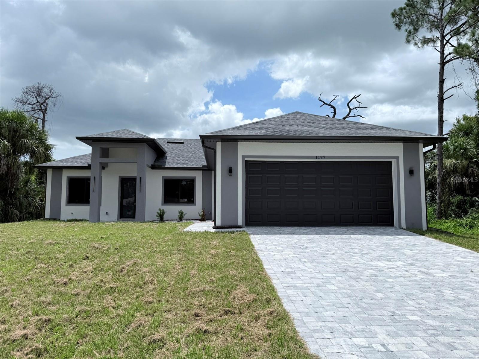 Introducing a newly built four-bedroom, three-bath home in the heart of North Port. Offering 2,158 square feet of living space and 3,099 total square feet, this 2025 residence blends modern design with functional living and refined finishes.

The open-concept layout connects the living and dining areas, ideal for everyday comfort and entertaining. The gourmet kitchen features stainless steel appliances and upscale finishes. Luxury vinyl flooring flows throughout, complemented by impressive 10-, 12- and 13-foot ceilings that enhance natural light and spaciousness.

The primary suite offers a private retreat with a spa-inspired bath, including a soaking tub, walk-in shower, dual vanities and an oversized walk-in closet. Additional highlights include a laundry room with sink and a pre-planned layout for future upgrades.

Exterior features include contemporary elevation details, sliding windows, a metal-and-glass front door, rear soffit lighting, and strategically placed gutters. The lot is pool-ready with summer kitchen connections already in place. A rare opportunity to own new construction in an established North Port location. Brand New Home, Priced to Sell!
