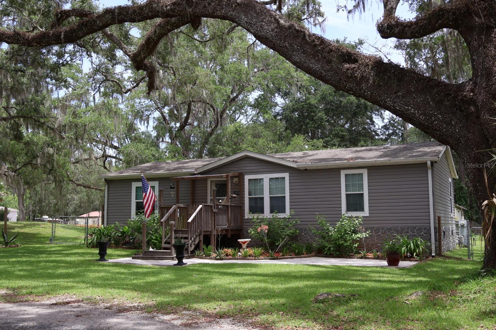 This lovely home has an open greatroom with a modern look, the living room, dining area and kitchen is one big open area. I love the 4ft x 6ft kitchen island. The Master bath is spacious and the Master bedroom has plenty of room for the ergonomic king sized bed. The other 2 rooms are well laid out. All the closets are walk-ins. All kinds of storage areas throughout the property. The 30 x 32 foot awning has a 50 amp hook up for campers. A parking area with a roll up door and a 12ft x 10ft workroom. Butted to the back is a matching building with a 18ft x 20ft shop/work area with all custom wood constructed shelves, tables and display areas. This has an upstairs area used for storage as well. This area has potential to become an apartment. Both workroom areas have window unit cooling. The house has fresh paint in the main rooms and MBs and ready to move in. This home is set up with preppers in mind. This home includes a whole house Generac with a 500 gallon tank. Comes with a 160ft well with a whole house filtration system. A good portion of the backyard is fenced in for kids and dogs. This property has potential for residential agriculture or commercial property. There is 1.12 acres here. There are many items going with the house including the lawn tractor. Must see to appreciate!