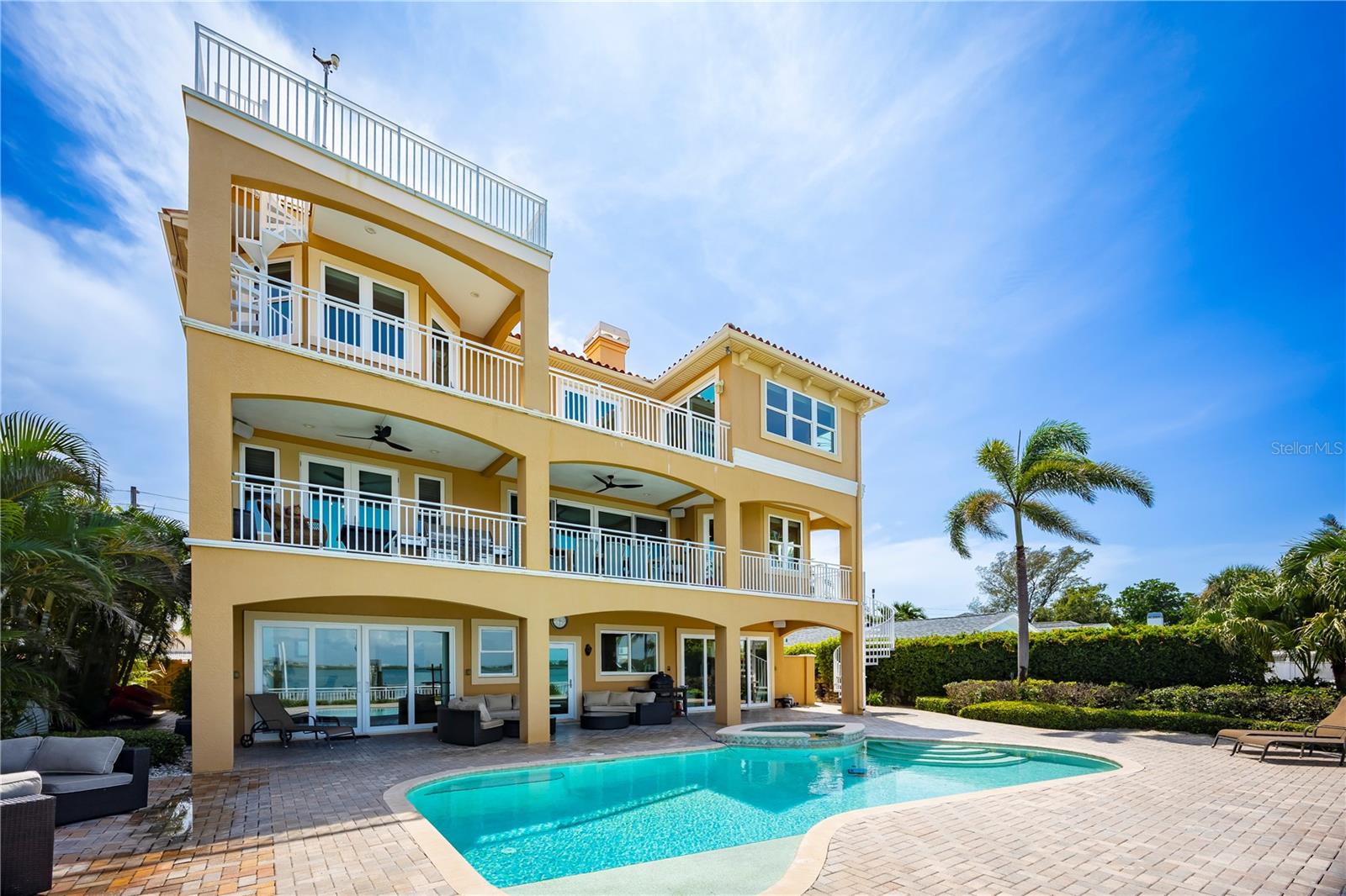 Welcome to 306 Harbor Drive in Indian Rocks Beach—a custom-built waterfront pool home on the Intracoastal Waterway offering over 4,500 sq ft, 5 bedrooms, 4 baths, a private dock with a 25,000 lb boat lift, and direct Gulf access. From the moment you enter, wide-open water views take over, visible from nearly every main living space. Built by its original builder-owner, this home was designed for true coastal living, boating, and entertaining. The oversized primary suite (27x37) features a fireplace, private waterfront balcony, and a spa-style bath with soaking tub, dual vanities, and walk-in shower. The main living area flows into a chef’s kitchen with custom wood cabinetry, granite countertops, large island, walk-in pantry, and butler’s pantry connecting to a coffered-ceiling formal dining room. A flexible bedroom with water views works perfectly as a home office or guest suite. The lower level offers a bonus/social room opening to the pool deck, plus a full bath for seamless indoor-outdoor living. Enjoy a saltwater pool, heated spa, and expansive waterfront space designed for sunset nights and entertaining. Additional features include a private elevator to all levels, rooftop terrace with panoramic Intracoastal views, 5-car garage with optional climate-controlled gym, smart home features, high ceilings, and no HOA. This home performed exceptionally well during recent storms, offering added peace of mind. Short-term rentals are allowed, creating strong income potential, and current flood insurance is under $1,800 per year. Located just a short walk to the beach, Brown Park, tennis courts, restaurants, and local favorites, this is a rare opportunity to own a luxury waterfront home with deep water access in one of Pinellas County’s most desirable coastal communities.