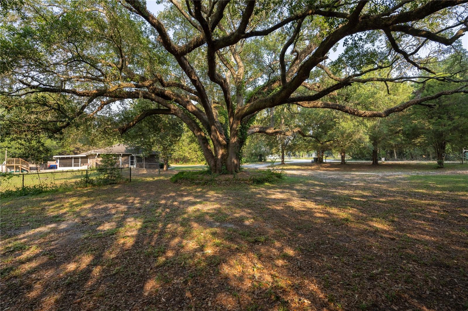 Discover the space, flexibility, and updates this beautifully maintained brick home has to offer on approximately 1.71 acres. Conveniently located just off Hwy 247/Branford Highway outside the city limits, this property offers a blend of privacy and seclusion while still providing easy access to shopping, dining, I-75, Live Oak, Fort White, and nearby everyday conveniences.

Inside, you’ll find a large great room ideal for gathering and entertaining, a separate dining room, and an oversized kitchen featuring epoxy countertops, a gas range and oven, side-by-side refrigerator, dishwasher, abundant cabinetry, and luxury vinyl plank flooring. Luxury vinyl plank flooring extends throughout much of the home, and sliding glass doors with built-in blinds lead to a screened porch overlooking the above-ground pool and deck area.

The flexible floor plan includes two spacious primary-style suites with en suite bathrooms. One oversized primary retreat features a private exterior entrance and accessibility-friendly features including a ramp entry and expansive walk-in shower, making it ideal for a variety of living arrangements and offering potential for an in-law suite setup. This suite also includes barn doors leading to the bathroom, ceramic tile flooring, a large walk-in closet, and linen storage. Additional living space includes a flex room currently being utilized as a bedroom, as well as an additional bonus/flex space that offers versatility for a variety of uses.

Additional improvements and features include a brand-new roof, updated electrical with two panels, two AC units, whole-house water filtration system, brand-new well system, RV hookup, circular driveway, fully fenced backyard with multiple gate entries, and multiple covered parking areas. One of the large carport areas includes power and workshop space, providing added flexibility for hobbies, storage, projects, or equipment needs.

Offering a combination of acreage, updated features, flexible living space, and a convenient location with added privacy, this property presents a unique opportunity with room to spread out both inside and outside.