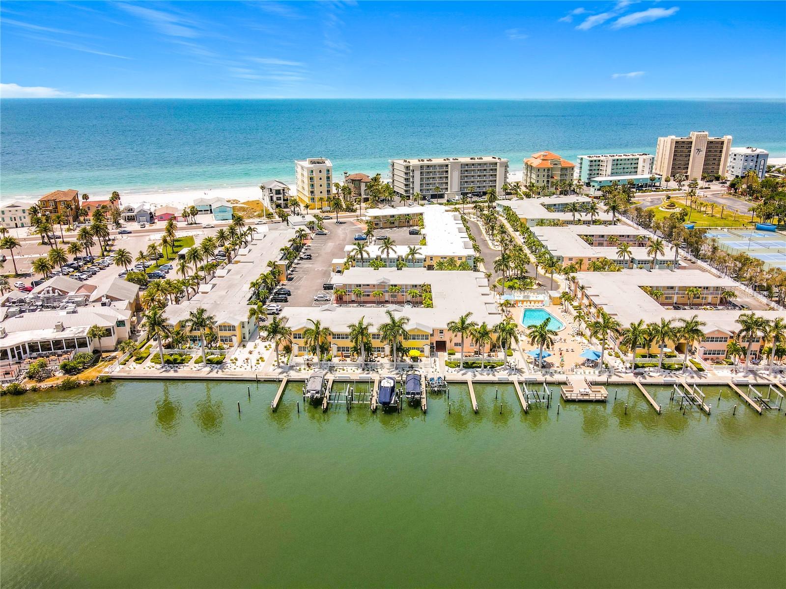 BOAT SLIP WITH LIFT INCLUDED WITH THIS CONDO - Experience the best of waterfront living in this beautifully updated, completely furnished, ground-floor condo sitting right on the Intracoastal waterway. This unit is very custom and one of a kind. Offering 2 bedrooms and approximately 950 sq ft, this turn-key residence features breathtaking, direct Intracoastal Waterway views from nearly every room and steps away from the beach.  Designed with versatility in mind, this property is ideal as a high-yield short-term rental or a private coastal retreat. Step outside to your private waterfront patio, complete with comfortable seating and a large shade umbrella—perfect for relaxing or entertaining while enjoying the panoramic water views.  The interior showcases a thoughtfully designed floor plan filled with natural light, abundant closet space, and stylish, new furnishings throughout. The custom kitchen is equipped with updated cabinetry, modern appliances, and enhanced lighting, along with a dedicated coffee and beverage  wet bar featuring a sink, glass cabinetry, and elegant glassware.This fully furnished unit comfortably sleeps six with two queen beds and a queen sleeper sofa. Additional features include three large Samsung LED TVs, Wi-Fi, a landline, and secure keyless entry at both front and rear doors. Beach gear, fishing poles, and tackle are also included, making it truly move-in or rental-ready.  Boating enthusiasts will appreciate the included boat slip with a 10,000 lb lift and dock box.  There are only 22 boat slips in this association and this is one of the condos that offers a boat slip with the condo. There is convenient parking located just outside the front door. New window screens were recently installed.  Don’t miss this rare opportunity to own a waterfront gem in a prime Indian Shores location—where income potential meets effortless coastal living.  This condo offers the best of both worlds - the beach is just across the street with a special walkway and lighted crosswalk from Barefoot.  The Intracoastal is right out your back door.  The resort offers a heated pool, clubhouse, putting green and fishing pier.  This unit comes with its own boat slip and lift.  There is also an onsite rental office that can help with your rentals if you would like.   Don't miss this truly unique opportunity.,