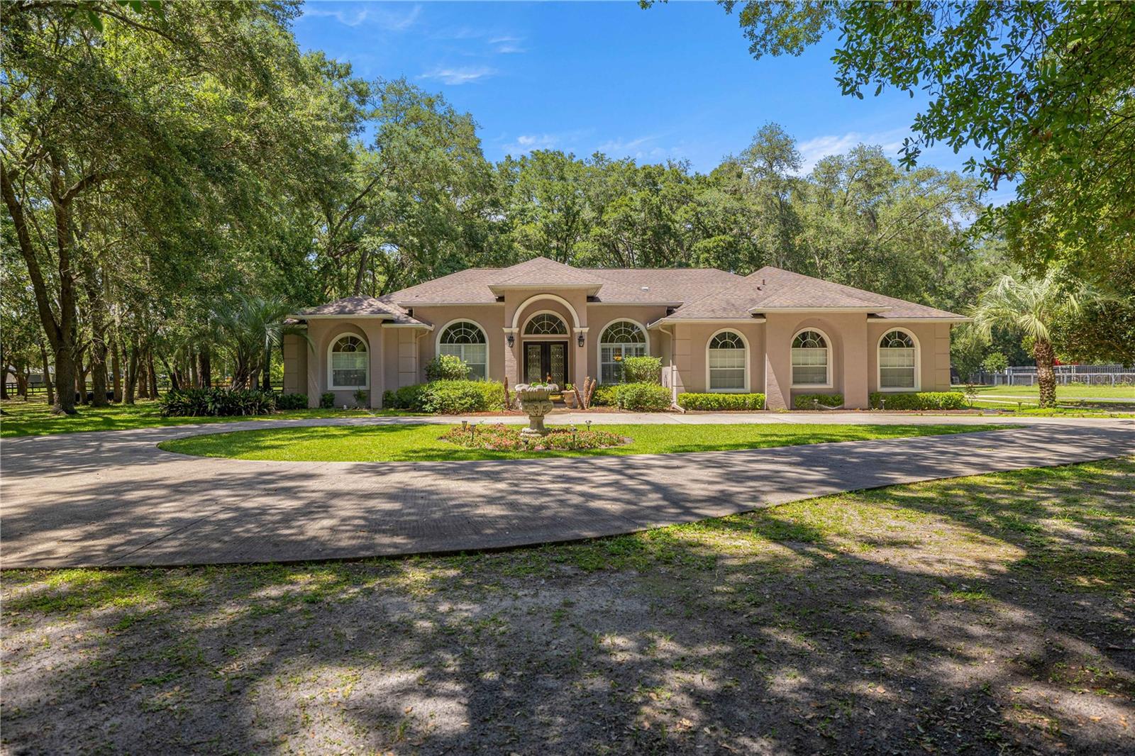 Welcome to this elegant 3-bedroom, 3-bath home offering 2,862 square feet of thoughtfully designed living space on 2.17 A-1 zoned acres. Tucked behind a gated entrance on a quiet road, this exceptional property offers the perfect blend of privacy, country living, and everyday convenience along Highway 200.

Step inside to soaring vaulted ceilings and expansive living spaces filled with natural light, creating a warm and inviting atmosphere. The spacious layout includes multiple living and sitting areas, along with a separate den or office, providing flexibility for work or relaxation. A formal dining room is ideal for hosting gatherings, while the breakfast nook off the kitchen offers a cozy space for casual dining. The kitchen features all-new appliances and flows seamlessly into the main living areas, making it perfect for entertaining. Throughout the home, pride of ownership is evident in the meticulous care provided by the sellers.

The oversized primary suite serves as a true retreat, offering generous space for a sitting area, a large walk-in closet, and a luxurious ensuite bathroom featuring dual vanities, a soaking tub, and a separate walk-in shower. Two additional bedrooms and two additional full bathrooms provide comfort and convenience for family and guests, with one guest bathroom offering direct access to the lanai—perfect for indoor-outdoor living.

Step outside to the updated screened lanai featuring a chef-inspired outdoor kitchen and bar, creating an ideal setting for entertaining or relaxing year-round. The expansive 2.17-acre property offers privacy, space, and freedom with no HOA or CDD restrictions, all enhanced by a gated entrance for added peace of mind.

Conveniently located just off Highway 200, this property provides quick access to Ocala’s shopping, dining, medical facilities, and everyday amenities while still offering the peace and space of country living. This is a rare opportunity to enjoy acreage, privacy, and convenience all in one exceptional home.
