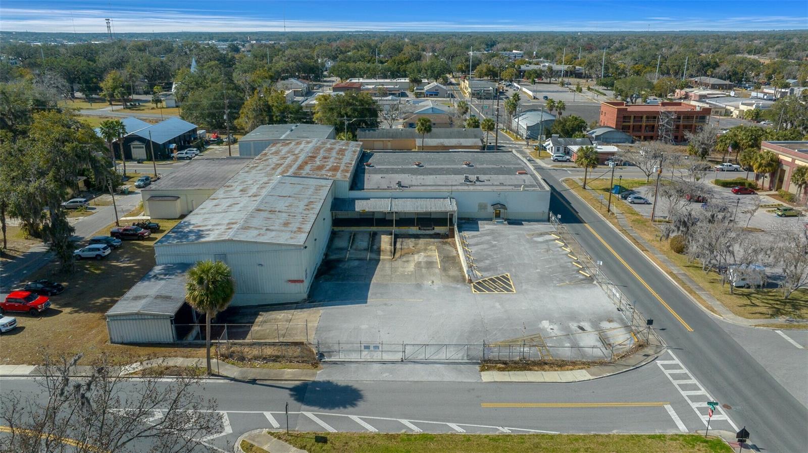 This 1.34-acre property features a 30,120± SF industrial and commercial building located in Ocala. This sprinkled, single-story facility offers clear ceilings ranging from 14.5' to 22.5'. Built for straightforward logistics and daily operations, the site is equipped with seven loading docks making it well-suited for standard distribution, service, or storage needs. Situated on a corner lot just two blocks from a city public parking lot, the property falls within an Opportunity Zone with flexible FBC zoning, allowing for a variety of commercial uses. A large portion of the building is air conditioned, providing for office space opportunity. Positioned just southeast of Downtown Ocala, it is near the Marion County Courthouse and AdventHealth, providing direct access to US-301/441 and practical routing to Interstate 75 via SR 40. Inquire today!