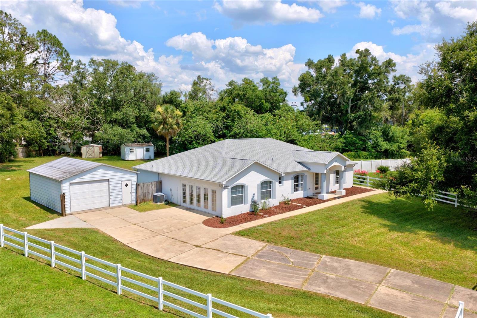 Virtually Staged. Charming 3-bedroom, 2-bath home on a spacious 0.56-acre lot, offering room to live, work, and store all your toys. The flexible floor plan includes a separate den and a formal dining room, perfect for a home office, playroom, or extra entertaining space. A large double-car garage can be converted back to a garage and provides convenient attached parking (now has french doors and was converted to living space), while a detached 20x25 garage adds incredible bonus space for a workshop, boat, RV, or extra vehicles. The west-facing backyard sets the stage for beautiful afternoon sun and gorgeous sunset views — ideal for relaxed evening entertaining, especially during Florida's cooler months. Enjoy the privacy and space of nearly half an acre with quick possession available — move in on your timeline. Don't miss this rare combination of living space, storage, and outdoor lifestyle in a desirable Ocala location.