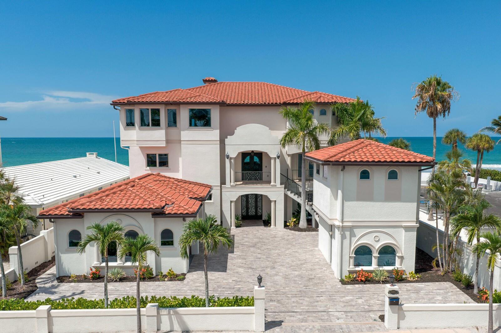 Pure Beachfront Magnificence awaits on the stunning sands of pristine Redington Beach in this outstanding Gulf-front estate. Enjoy endless water views, recreation and amazing sunsets on the white sand beach in a quiet residential community. This grand estate boasts approximately 80 feet of water frontage on a deep 200-foot lot and offers a newly painted interior for a fresh, transitional appeal. Offering fine finishes and expansive living spaces across three levels of concrete block construction, the residence features impact windows and doors, soaring ceilings, impressive floor-to-ceiling windows overlooking the beach and multiple waterfront terraces. Enter through the stately double-door, leaded-glass entry to travertine and hardwood floors, a private elevator and custom architectural details. The new chef’s kitchen provides top-of-the-line Thermador stainless steel appliances, new custom cabinetry and counters, and a large center island opening to the great room with a gas fireplace, sitting and breakfast areas, and an elegant formal dining room. Make your escape to the private primary suite through an elegant double-door entry to spectacular views and luxurious appointments, including a gas fireplace, built-in entertainment center, sitting area, custom closet and dressing room, and a private covered terrace offering panoramic views of the Gulf. An opulent primary bath features a soaking tub and dramatic oversized shower. Three spacious guest suites, each offering Gulf views, are elegantly appointed with private full baths and access to two private balconies overlooking the beach. A detached private mother-in-law suite offers the fifth bedroom and bath along with a kitchenette. Designed to deliver an outstanding beachfront lifestyle, the outdoor living and entertaining area boasts over 1,000 square feet, with an oversized heated saltwater pool, spa, automated LED lighting, a spacious covered entertaining area, travertine paver surround and low-maintenance turf. Built to exacting standards, additional appointments include smart home features and a security system. A generous driveway and oversized attached six-car garage provide exceptional parking capacity, plus an adjacent residents-only parking area perfect for overflow parking or entertaining. Located in a quiet residential area that offers easy access to dining, shopping, Tampa International Airport and entertainment. This is one of the few existing beachfront properties currently available that offers the scale, construction quality and refined finishes comparable to newer luxury construction.