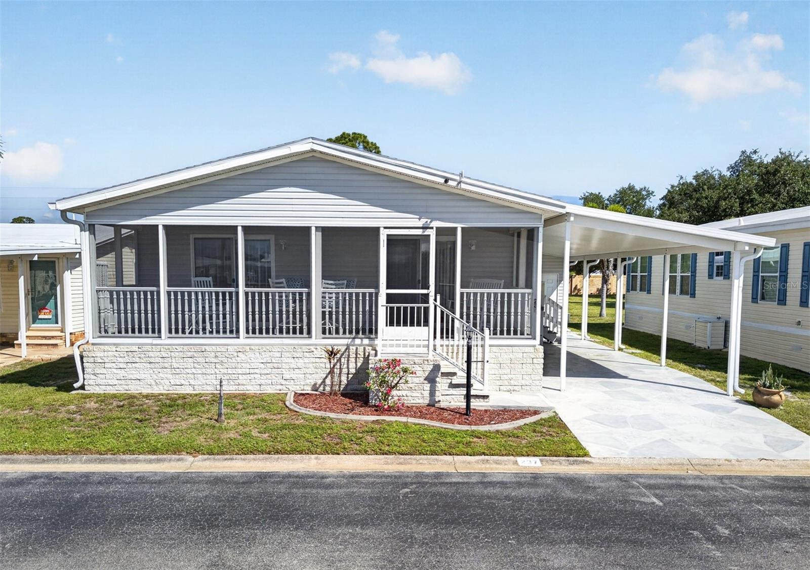 TURNKEY/FURNISHED 3 bedroom, 2 bath manufactured home in the 55+ gated community of Burnt Store Colony! Share certificate valued at $32k and convenient handicap accessible lift in carport are included. From the moment you arrive, the beautiful curb appeal features brick accents and a flagstone-pattern driveway leading to a spacious covered screened front porch perfect for enjoying your morning coffee or entertaining guests. Step inside, and you’re greeted by an open-concept floor plan featuring high ceilings, crown molding plus living and dining areas with double sliders and large windows providing an abundance of natural light. Spacious kitchen features white cabinetry, solid surface countertops, closet pantry and breakfast bar for casual dining. Generous primary suite offers private bath with dual sinks and handicap accessible shower with bench. Guests will feel right at home in two nicely sized additional bedrooms sharing a separate full bath. Additional features include storage room or workshop with access from carport and covered back patio overlooking large greenbelt area for extra privacy. Burnt Store Colony enhances your lifestyle with an array of amenities, including a gym, library, screened lap pool and spa, tennis and pickleball courts, shuffleboard, dog park and two clubhouses with a full-service kitchen and entertainment space. Located just 20 minutes from downtown Punta Gorda and 30 minutes from downtown Fort Myers. Additionally, it's close to Heritage Landing and Burnt Store Marina, offering access to resort and golfing facilities, waterfront dining, and entertainment. It is conveniently located to the airport, restaurants, shopping and award-winning fishing and boating. Burnt Store Colony Ownership Share gives you a lower monthly HOA and a vote on budgets and election of Board of Directors.  Don't miss out on this opportunity to join this friendly, well-maintained community! Schedule your private showing today!