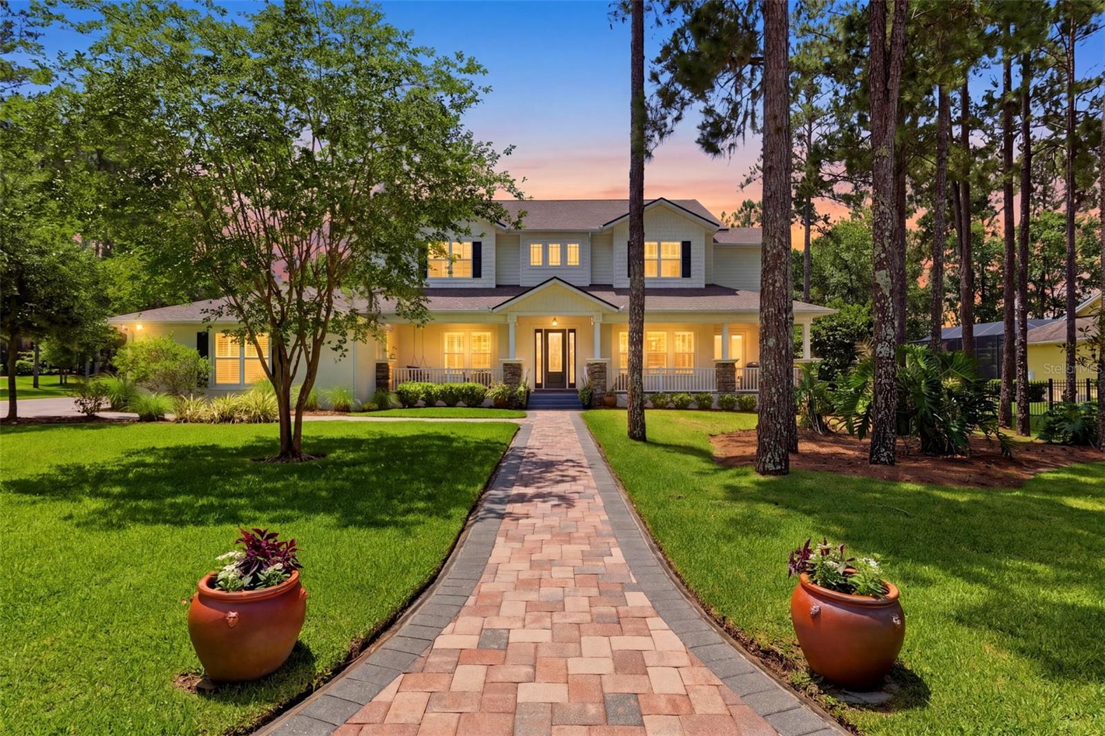Welcome to one of the most iconic homes in Southern Hills Plantation, a stunning custom-built luxury estate positioned along the Pete Dye Championship Golf Course with sweeping pond and fairway views in the front and a private preserve behind. This extraordinary residence has become one of the signature homes within the community and offers an unmatched combination of architectural presence, craftsmanship, and resort-style living.

This expansive two-story home features 5 bedrooms, 4 full bathrooms, formal living and dining rooms, a large family room, dedicated office space, additional flex/yoga room, private elevator, and an incredible 7-car garage configuration that is nearly impossible to find in Southern Hills.

The welcoming wraparound front porch creates unforgettable curb appeal and sets the tone for the elegance found throughout the home. Inside, custom finishes immediately stand out including beautiful wood flooring, extensive millwork, plantation shutters, soaring ceilings, elegant wainscoting, designer lighting, and spacious open living areas filled with natural light. French doors throughout create a seamless connection between indoor and outdoor living.

The chef’s kitchen was designed for entertaining and daily living alike, featuring marble and granite countertops, double ovens, custom cabinetry, oversized prep areas, dedicated coffee station, walk-in pantry with water line for an additional ice maker, spacious mud room, and oversized laundry area.

Adding warmth and character throughout the home are three fireplaces, including two gas fireplaces—one being a dramatic double-sided centerpiece—as well as an additional wood-burning fireplace.

One of the home’s standout features is the private elevator, offering convenience, luxury, and long-term practicality. Upstairs, the primary suite feels like a private retreat complete with spa-inspired bath areas, an extraordinary “Queen’s Closet” with sink and makeup station, and a separate oversized men’s walk-in closet. Every bedroom features its own walk-in closet.

The home is fully wired as a smart home with every room hardwired for internet connectivity. Additional smart features include app-controlled above-cabinet lighting, backyard safety lighting, adjustable landscape lighting timers, and hot/cold water hookups on both the lanai and near the maintenance garage door.

The outdoor living experience rivals a private resort with an expansive screened pool area featuring multiple entertaining spaces, grilling areas, sunshelf, and a dramatic 10-foot-deep pool. The fully fenced backyard opens to a peaceful preserve setting with no rear neighbors.
Car enthusiasts and entertainers will appreciate the massive 7-car garage offering endless possibilities for a workshop, golf simulator, theater space, gym, game room, or showcase collection.

Additional highlights include approximately 6,000 square feet of professionally cleaned, re-sanded, and sealed pavers completed in December 2025 and a brand-new roof installed in February 2026.

Located within the gated Southern Hills Plantation Club, residents enjoy access to the Pete Dye Championship Golf Course, elegant clubhouse, resort-style pool, poolside dining, tennis and pickleball courts, fitness center, spa services, walking trails, and a true country club lifestyle approximately 50 minutes from Tampa International Airport.
