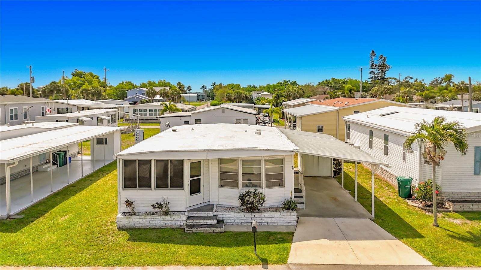 Welcome to 80 Del Rio Drive in Palmetto, where comfort meets the relaxed charm of Florida waterfront living.

This inviting 2-bedroom, 1.5-bath home is thoughtfully designed for both everyday living and entertaining. The home features a spacious kitchen with ample cabinetry, a dedicated dining area, and a large living room that provides plenty of room to relax or host guests. An enclosed front porch offers the perfect spot to enjoy your morning coffee, unwind in the evening, or create a cozy bonus living space.

Offered fully furnished and move-in ready, this property makes for an easy transition—whether you're looking for a seasonal getaway or a full-time residence. Just bring your personal touches and start enjoying the Florida lifestyle from day one.

Located in the highly sought-after Tropic Isles Co-Op, this 55+ waterfront community offers an exceptional array of amenities. Residents enjoy a deep-water marina with direct access to Tampa Bay and the Gulf of Mexico, perfect for boating and fishing enthusiasts. The community also features waterfront parks, a heated pool and spa, fitness center, shuffleboard courts, kayak launch, and an active social calendar that makes it easy to connect with neighbors and enjoy the best of coastal living.

Whether you're seeking relaxation, adventure on the water, or a vibrant community atmosphere, this home offers it all.

Come experience the best of Florida waterfront living—your next chapter starts here.
