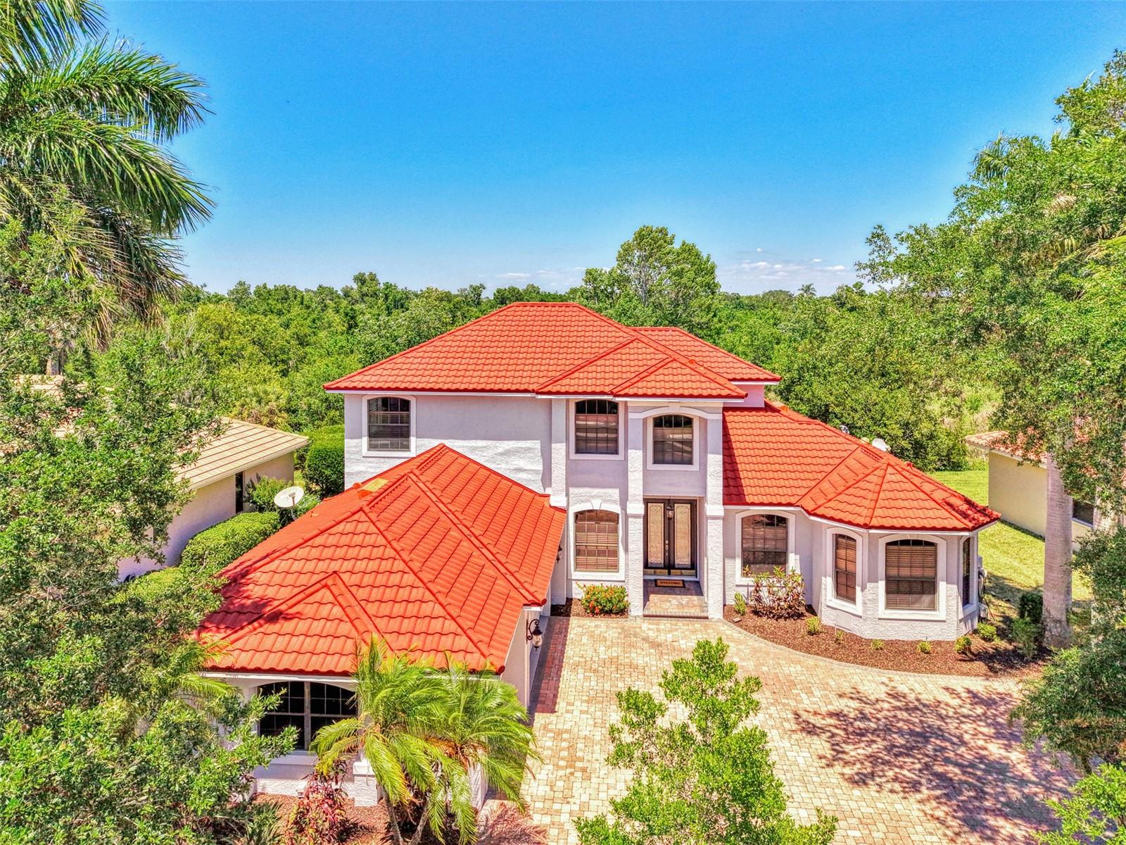 One or more photo(s) has been virtually staged.  Welcome to Three Oaks—where refined living meets natural serenity.  This exceptional 4-bedroom + den, 3.5-bath home with a 3-car garage is perfectly positioned along a 125-acre private preserve and lake, offering rare privacy and breathtaking, unobstructed views—truly a bird-watcher’s paradise.  Step through elegant double glass entry doors into a home defined by timeless architectural details, including graceful arches, tray ceilings, crown molding, and custom niches—features rarely found at this price point. Soaring ceilings, rich bamboo and plank wood flooring, and expansive windows fill the home with warmth and natural light.  The thoughtfully designed layout offers a first-floor primary suite and den for convenient single-level living. At the heart of the home, the gourmet kitchen features granite countertops, custom wood cabinetry, and ample space for both casual dining and entertaining.  Step outside to your private retreat. The screened lanai boasts a sparkling pool and spa, and peaceful preserve and lake views—perfect for relaxing evenings or hosting guests in complete privacy.
Recent updates provide peace of mind, including a new roof (April 2026), fresh interior and exterior paint, new second-floor flooring, a new pool pump (2026), lanai hurricane shutters, and a brand-new portable grill.  Ideally located near top-rated schools, premier shopping and dining, and the world-renowned beaches of Sarasota, this home offers the perfect balance of luxury, comfort, and location.  Schedule your private showing today and experience the best of Three Oaks living.