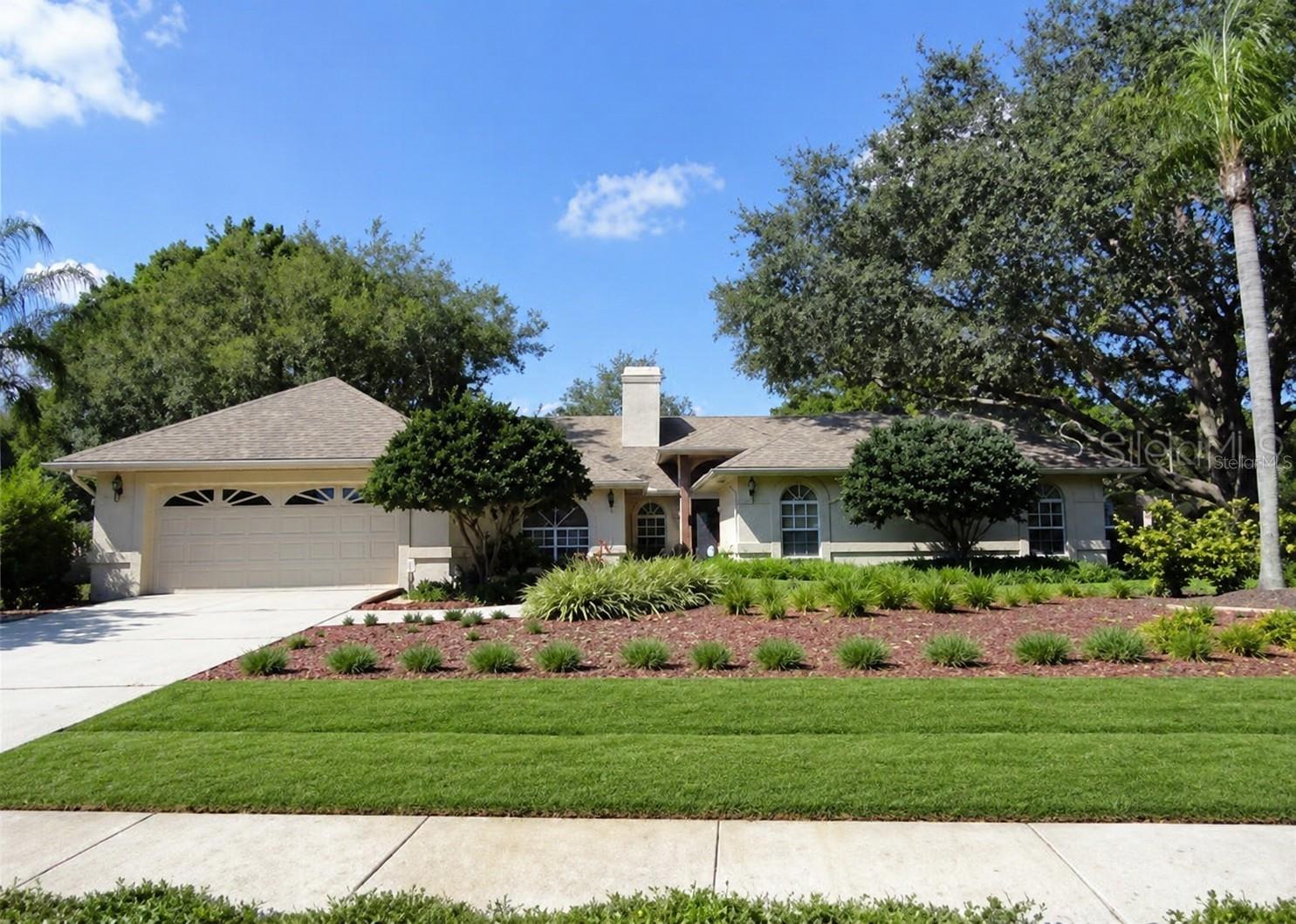 Welcome to this beautifully maintained residence in the highly sought-after guard-gated community of The Manors at Crystal Lakes, where comfort, character, and everyday livability come together.

A picturesque streetscape sets the tone with mature landscaping, custom xeriscaping, fresh sod, and majestic oak trees framing a landscaped walkway that leads to a brick-accent front porch and a warm, inviting entry.

Inside, soaring cathedral ceilings and luxury wood-look tile flooring immediately elevate the space, filling the home with light and openness. Arched windows with custom plantation shutters add architectural charm throughout. The formal living room offers a flexible space that can serve as an elegant sitting area or game room, anchored by a striking double-sided fireplace that seamlessly connects to the family room.

The updated kitchen overlooks the main living areas and features white cabinetry, granite countertops, stainless steel appliances, pendant lighting, and generous workspace designed for both everyday cooking and entertaining.

The primary suite is a true retreat with vaulted ceilings and a fully remodeled en-suite bathroom featuring custom cabinetry, granite countertops, a jetted soaking tub, and a walk-in shower. Three additional guest bedrooms offer spacious layouts and large closets, providing comfort and flexibility for family or guests.

Outdoor living is designed for year-round enjoyment with a screened-in resurfaced pool, brick paver deck, and a renovated full pool bath. The outdoor television, pool bar, bar stools, and lounge chairs all convey, creating a ready-to-enjoy entertainment space from day one.

Additional features include a two-car garage with storage shelving, a large laundry room with built-in cabinetry, and abundant interior storage throughout.

Residents of The Manors at Crystal Lakes enjoy 24-hour guard-gated security along with tennis and pickleball courts, a clubhouse, playground, and year-round community events. A rated Lutz elementary K-8, highly desirable Lutz Preparatory Charter School K-8, Coveted Steinbrenner High School 9-12 shopping, dining, Tampa International Airport, downtown Tampa, and the Gulf Coast beaches.

A rare opportunity to own a home that blends thoughtful updates, architectural charm, and an exceptional location in one of Northwest Hillsborough County’s most established communities with low HOA, no CDD.