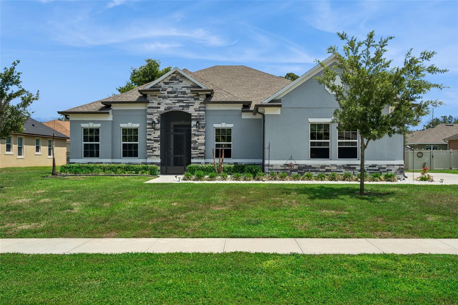 One or more photo(s) has been virtually staged. This well-maintained home is situated in the highly sought-after gated community of Majestic Oaks in Leesburg. The property features an open floor plan connecting the living room, dining area, and kitchen, providing functional living and entertaining space. The primary bedroom includes a large walk-in closet and an en suite bathroom with a walk-in shower featuring multiple shower heads and a separate tub. A secondary en suite bedroom also offers a walk-in closet and walk-in shower, suitable for guests or multi-generational living. The kitchen includes a walk-in pantry, ample cabinetry, and a countertop with seating. Additional interior space includes an office/den, offering flexibility for work or other uses. This property features a sparkling heated pool enclosed within a screened birdcage, creating the perfect private outdoor retreat, complemented by beautifully sealed paver surfaces. Screened front porch, solar tube in the laundry room. The home is equipped with whole-house window tinting for enhanced energy efficiency and privacy, along with ceiling fans in every bedroom. Additional upgrades include an epoxy-coated garage floor, comfort-height toilets throughout, a full gutter system, and a hot water recirculation system for near-instant hot water. A detached shed provides convenient extra storage space. This home blends practical upgrades with everyday luxury, ready for you to move in and enjoy. The property also includes deeded lake access with a community dock located across the street.