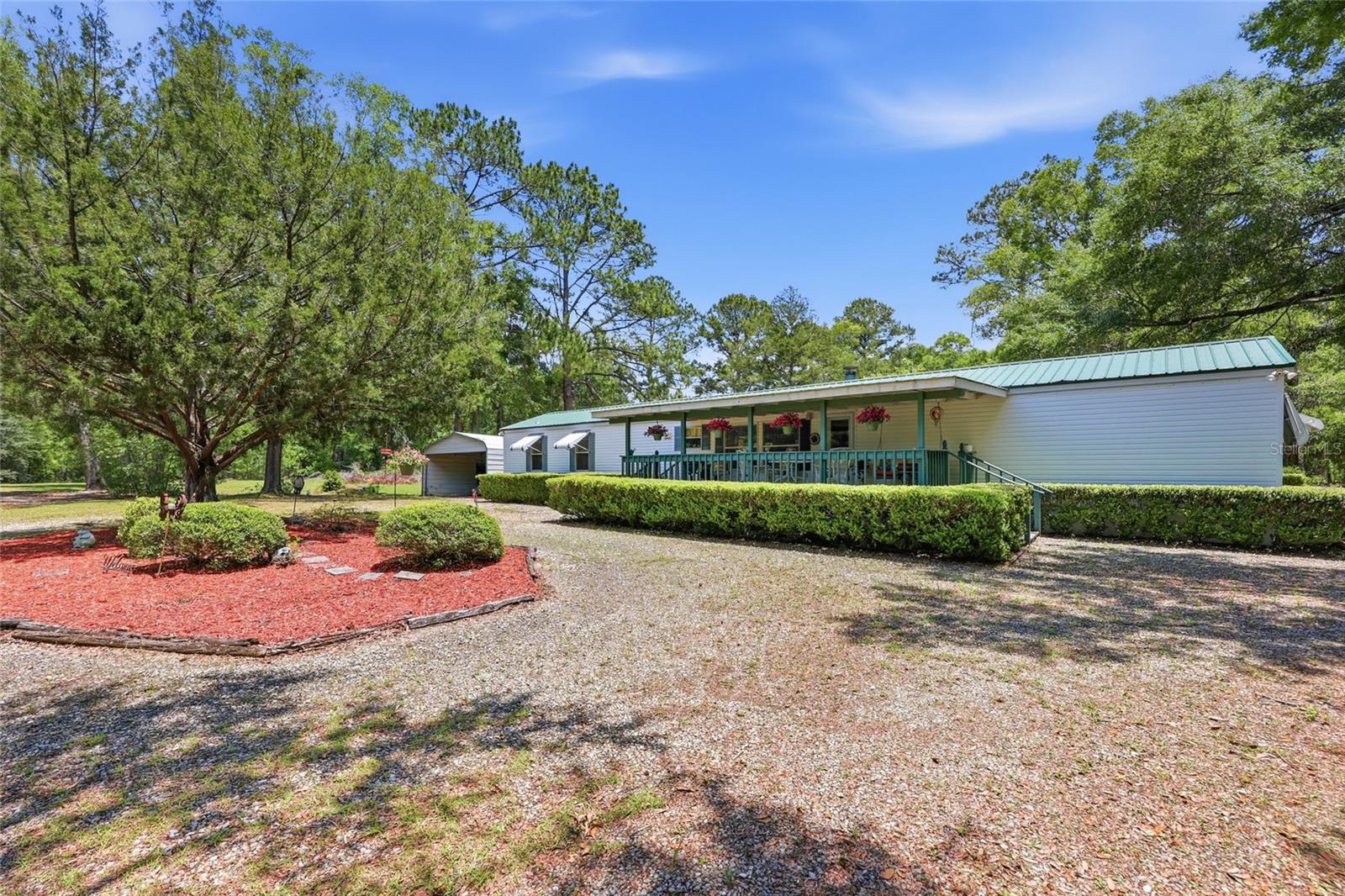 Tucked away on 4 beautiful acres in North Florida, this 3BR/2BA well-maintained property offers the privacy and peaceful setting so many buyers are looking for. The land is partially cleared with scattered mature oak trees, established landscaping, and a picturesque setting that gives the property a true Old Florida feel. Enjoy quiet mornings and relaxing evenings from the large covered front and back porches overlooking the property. Located on a paved road, this property offers both convenience and country living. The clean and well cared for 3BR/2BA mobile home features a spacious layout with a large kitchen offering plenty of cabinet and counter space, a comfortable living room with a fireplace, and a split-bedroom floor plan. The home has been lovingly maintained and is move-in ready. Conveniently located just a short drive from downtown Lake City, shopping, restaurants, medical facilities, and everyday amenities while still offering the peace and privacy of acreage living. Outdoor lovers will appreciate being close to many of North Florida’s natural springs and rivers including Ichetucknee Springs State Park, Ginnie Springs, and the Suwannee River for boating, kayaking, tubing, and fishing. This property is the perfect combination of rural charm, convenience, and natural beauty.
