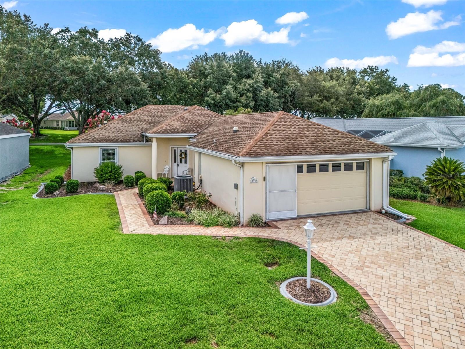 Welcome to easy Florida living with this fully furnished and turnkey home with a GOLFT CART. This home includes everything you need to start enjoying from day one Perfectly positioned in the highly desirable Villa section of Stonecrest, this beautifully maintained and tastefully furnished 2-bedroom, 2-bath villa with a den offers the ideal balance of comfort, functionality, and low-maintenance living. With 1,704 square feet under air, this home is truly the perfect size. From the moment you arrive, you'll be impressed by the home's exceptional curb appeal. A brick paver driveway and walkway lead you to the welcoming entrance, while beautifully landscaped flower beds with decorative curbing create a charming first impression. Step inside to discover an open and airy floor plan enhanced by soaring vaulted ceilings, abundant natural light, and multiple solar tubes that brighten the interior throughout the day while helping reduce energy costs. The spacious living and dining areas flow seamlessly together, creating an inviting atmosphere ideal for both everyday living and entertaining. The well-designed kitchen overlooks the main living space, allowing you to stay connected with family and guests. A den adds extra sitting area or perfect area for office space. Just beyond, the enclosed climate-controlled lanai offers additional year-round living space, perfect for enjoying your morning coffee, reading a book, or entertaining friends. For those who love the outdoors, an additional screened lanai provides a peaceful retreat where you can relax and listen to the birds while enjoying Florida's beautiful weather. The generously sized primary suite serves as a private sanctuary, featuring two walk-in closets and an ensuite bathroom complete with a large walk-in shower and dual-sink vanity. The guest bedroom and second bathroom are thoughtfully positioned to provide comfort and privacy for visitors, while the versatile den offers endless possibilities as a home office, or additional guest space.  Additional features include an inside laundry area conveniently located within the garage, a one-car garage with extra room for a golf cart, and garage screens that allow you to enjoy fresh air while working on projects or relaxing in the garage space. Located within the Villa section of Stonecrest, exterior grounds maintenance is handled by the Property Owners Association, allowing you to spend less time working and more time enjoying life. Villa homeowners enjoy full-service lawn care provided by the Association, including grass cutting and edging, weeding and feeding, tree and shrub trimming, leaf blowing, and mulch application, as well as irrigation system maintenance and repairs. Stonecrest is one of Central Florida's premier 55+ gated golf course communities, ideally situated adjacent to The Villages. Residents enjoy an unparalleled lifestyle with resort-style amenities including multiple pools, pickleball courts, softball fields, fitness facilities, over 80 clubs and activities, and the renowned 18-hole championship golf course. The Broad Stripes Golf & Social Club serves as a vibrant gathering place for dining, entertainment, and social events. Best of all, shopping, dining, medical facilities, and all the conveniences of The Villages are just a short golf cart ride away. Whether you're looking for a full-time residence, seasonal retreat, or a low-maintenance lifestyle in a secure gated community, this exceptional villa offers it all.