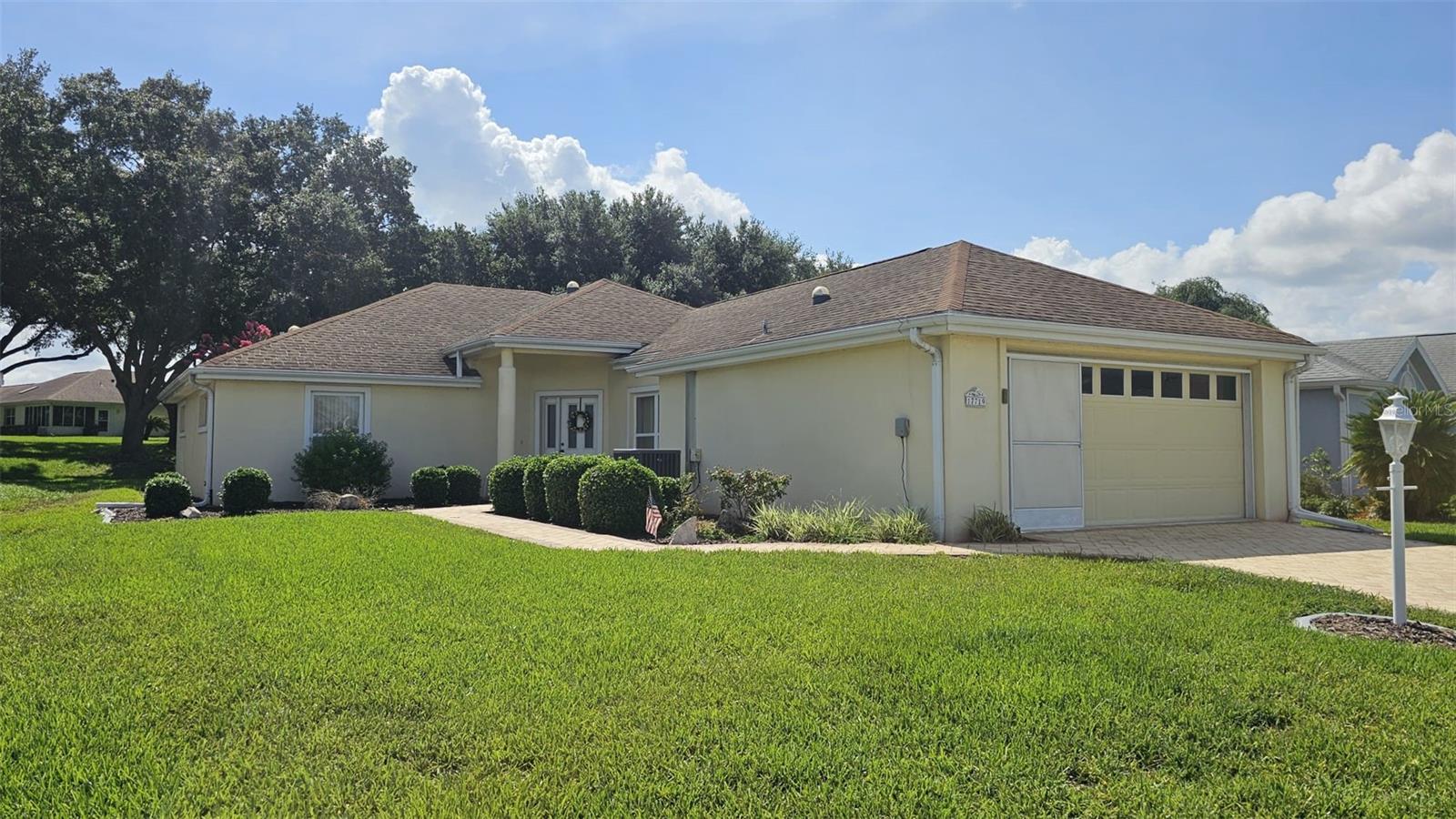 Welcome to easy Florida living with this fully furnished and turnkey home with a GOLFT CART. This home includes everything you need to start enjoying from day one Perfectly positioned in the highly desirable Villa section of Stonecrest, this beautifully maintained and tastefully furnished 2-bedroom, 2-bath villa with a den offers the ideal balance of comfort, functionality, and low-maintenance living. With 1,704 square feet under air, this home is truly the perfect size. From the moment you arrive, you'll be impressed by the home's exceptional curb appeal. A brick paver driveway and walkway lead you to the welcoming entrance, while beautifully landscaped flower beds with decorative curbing create a charming first impression. Step inside to discover an open and airy floor plan enhanced by soaring vaulted ceilings, abundant natural light, and multiple solar tubes that brighten the interior throughout the day while helping reduce energy costs. The spacious living and dining areas flow seamlessly together, creating an inviting atmosphere ideal for both everyday living and entertaining. The well-designed kitchen overlooks the main living space, allowing you to stay connected with family and guests. Just beyond, the enclosed climate-controlled lanai offers additional year-round living space, perfect for enjoying your morning coffee, reading a book, or entertaining friends. For those who love the outdoors, an additional screened lanai provides a peaceful retreat where you can relax and listen to the birds while enjoying Florida's beautiful weather. The generously sized primary suite serves as a private sanctuary, featuring two walk-in closets and an ensuite bathroom complete with a large walk-in shower and dual-sink vanity. The guest bedroom and second bathroom are thoughtfully positioned to provide comfort and privacy for visitors, while the versatile den offers endless possibilities as a home office, or additional guest space.  Additional features include an inside laundry area conveniently located within the garage, a one-car garage with extra room for a golf cart, and garage screens that allow you to enjoy fresh air while working on projects or relaxing in the garage space. Located within the Villa section of Stonecrest, exterior grounds maintenance is handled by the Property Owners Association, allowing you to spend less time working and more time enjoying life. Villa homeowners enjoy full-service lawn care provided by the Association, including grass cutting and edging, weeding and feeding, tree and shrub trimming, leaf blowing, and mulch application, as well as irrigation system maintenance and repairs. Stonecrest is one of Central Florida's premier 55+ gated golf course communities, ideally situated adjacent to The Villages. Residents enjoy an unparalleled lifestyle with resort-style amenities including multiple pools, pickleball courts, softball fields, fitness facilities, over 80 clubs and activities, and the renowned 18-hole championship golf course. The Broad Stripes Golf & Social Club serves as a vibrant gathering place for dining, entertainment, and social events. Best of all, shopping, dining, medical facilities, and all the conveniences of The Villages are just a short golf cart ride away. Whether you're looking for a full-time residence, seasonal retreat, or a low-maintenance lifestyle in a secure gated community, this exceptional villa offers it all.