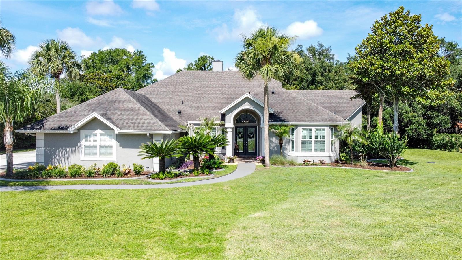Calling all car enthusiasts or artisans needing a large, detached workshop on your property! This house has it all; including a gorgeous interior, huge pool and lanai equipped with an outdoor kitchen, and a large 30 x 30 detached 5 car garage/workshop in addition to a 2 car attached garage. This house is perfect for work and play! Situated on a rare, 1 acre lot in the coveted town of Windermere, this house is truly 1 of a kind. Surrounded by sweeping oak trees and quiet streets, you’ll feel miles away from the hustle and bustle of the city even though you’re right at its back door. Enjoy entertaining? This is your dream entertaining house with a HUGE kitchen (which was gutted in 2017), high end appliances including a Bosch cook top/built in oven, and all the refrigerating needs you could have, including a wine fridge and a brand-new LG thinQ refrigerator that makes cocktail ice. There is plenty of room for friends and family to sprawl out as this house boasts an eat in kitchen as well as a formal dining area, and dual living room/family room areas that are split by a gorgeous, wood burning fireplace giving this home the coziest, homiest feeling. Love to have fun pool days? There is an oversized 14 x 34 lanai off the rear of the home decked out with an outdoor kitchen from Paradise Grills perfect for grilling out and relaxing. The oversized pool is a perfect place to cool off afterwards. This home has so much charm as a sprawling 1 story on a huge lot with space between houses, which is a rare find in this area. The backyard is fenced in for your furry friends enjoyment, and there is even plenty of land left to build an in-law suite if that is something you desire to do. With a fully renovated kitchen, and newly renovated bathrooms, this home is truly a turnkey experience. The sellers have poured tons of money into this home, please see MLS attachments for full list of recent upgrades. This home is zoned for top ‘A’ rated schools of Orange County including Windermere Elementary, Bridgewater Middle, and Windemere High school making it a great pick for personal enjoyment and resale value. The home has a 2 car garage attached to the home, and a 4 car detached garage in the back. ****Updates the sellers have completed since purchase: New AC unit - main house (Jan 2023) - New water heater (Oct 2021) - New water chlorination filtration system (2025)- Custom trim and molding throughout house (2025) - Custom built in shelving (2025) - Both bathrooms updated w custom cabinetry (2022 and 2025) - aluminum fencing in backyard (2021) - New AC in back garage (Sept 2021) - New refrigerator – LQ ThinQ (2025) - Pool area concrete replaced with pavers and patio extended off the master suite (2022) - New septic drain field and septic pumped (2026)... additionally, the kitchen and master bathroom were gutted and completely renovated in 2017, roof is 2017.
