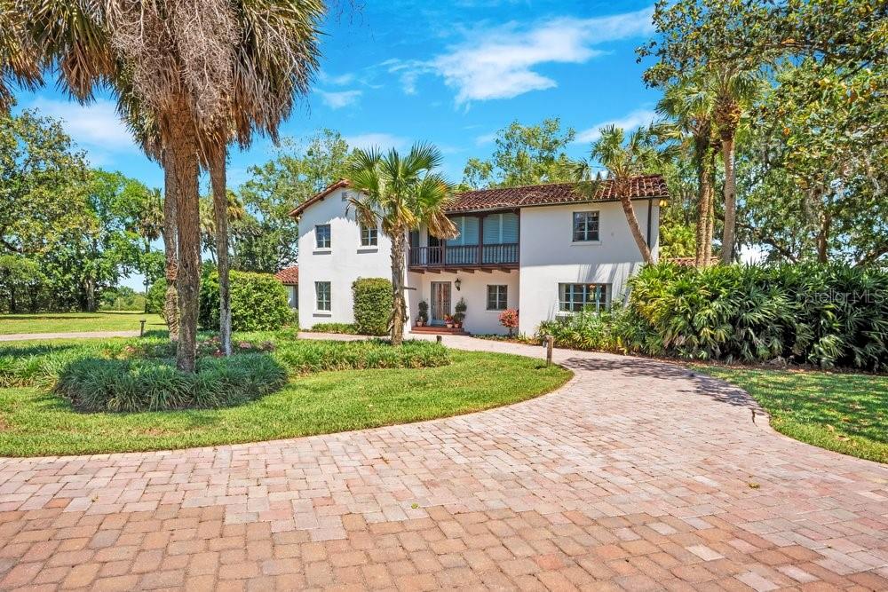 There are properties that can be purchased, and then there are properties that can only be inherited through a once-in-a-lifetime opportunity.
Offered publicly for the first time in its history, this extraordinary 1934 Mediterranean estate is one of Central Florida's true hidden treasures. Nestled among towering palms, grand oaks, and 40 pristine acres, the property is known to locals for its iconic entrance landmark, "The Wall." Rich in history, character, and craftsmanship, it represents a level of quality that simply cannot be replicated today. The approximately 5,100-square-foot residence showcases timeless architectural details, including original hardwood flooring, historic brick floors, exposed beams, sweeping archways, and beautiful Mediterranean-inspired tilework. Designed for both grand entertaining and intimate family gatherings, the home offers 4 bedrooms, 3 full bathrooms, and a semi-attached guest suite or private office with its own bath. Throughout the home, period details serve as a reminder of an era when homes were built to stand the test of time. Three fireplaces anchor the estate's most cherished gathering spaces, including the formal living room, formal dining room, and an extraordinary copper fireplace in the Florida sunroom—a truly rare feature that embodies the home's distinctive character and craftsmanship. Outside, a large swimming pool, mature landscaping, towering palms, and expansive outdoor living spaces create a setting that feels more like a private resort than a residence. A private gated drive, established gardens, and a park-like setting further enhance the estate's sense of privacy and grandeur. Formerly thriving orange groves, the land now serves as an income-producing hay operation. A whole-house generator, equipment barns, and expansive acreage provide both convenience and endless possibilities. The property is currently platted into 2.96-acre parcels, offering exceptional flexibility for future use—whether preserved as an extraordinary private estate, transformed into a private family compound, event venue, or equestrian estate, or developed into a collection of estate-sized homesites with the historic residence remaining at its center.