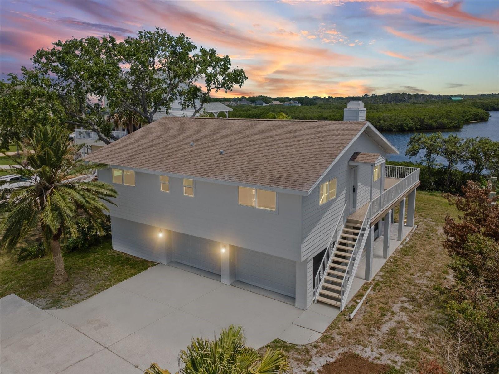 One or more photo(s) has been virtually staged. Welcome to your slice of paradise on the Gulf of Mexico, where every day ends with a breathtaking sunset over the water. This charming 2-bedroom, 3-bath elevated home captures the essence of coastal living — bright, open, and full of character.
Inside, you’ll find a bespoke kitchen filled with light, natural textures, and modern touches that make cooking feel effortless. The living area flows beautifully with beamed ceilings, a cozy fireplace, and wide windows framing stunning views from Howard Park to Clearwater.
Step outside to the expansive deck and savor the salt air, sea breeze, and endless horizon — perfect for morning coffee or evening gatherings under the stars. Below, the first-floor screened area provides bonus space ideal for relaxing in the shade. Flex rooms provide storage for your paddleboards and kayaks after a day on the water.  Moments from the historic Sponge Docks, fresh seafood restaurants, and Tarpon’s vibrant local culture, this home offers a rare blend of Old Florida charm and modern coastal comfort — a peaceful retreat that feels truly one of a kind.  Hurricane rated windows and sliding doors. Lower level is not included in square footage