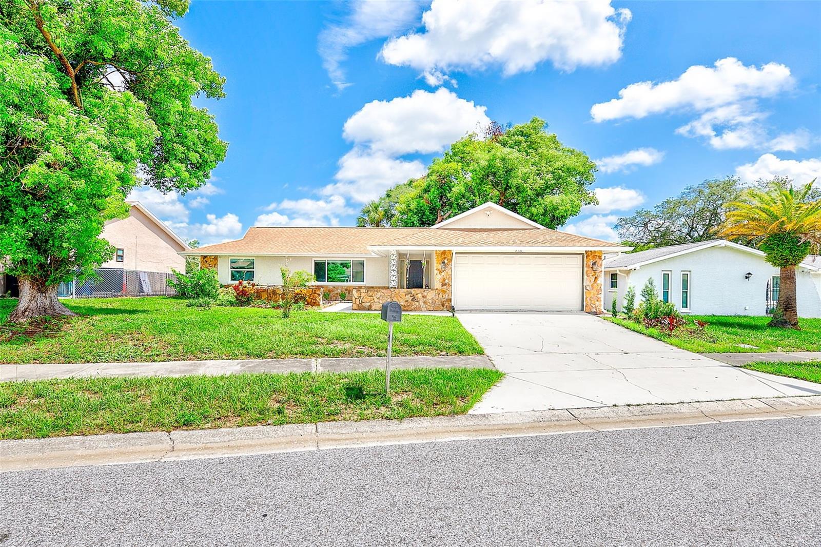 Move-in ready, warm and welcoming this lovely 2 bedroom, 2 bath home has everything you need for cozy comfort, including an open, spacious split floor plan with easy kitchen access to a large screened lanai and wrap-around deck. The kitchen features newer appliances, ample granite countertops, and a spacious closet pantry. A breakfast bar and separate dining area complete the space; perfect for enjoying relaxing meals at home or preparing for a backyard fiesta in the large, shaded backyard. This home has plank flooring throughout with new carpeting in each of the bedrooms and the secondary bathroom was fully renovated in 2022. The home has been well maintained and updated, with hurricane windows and doors installed in 2022 and 2023, the air handler and duct work replaced in 2022, and the electric panel and water heater recently replaced. Best of all, the property is not in a flood zone and there is no HOA.  Close to beaches, schools, hospitals, shopping and restaurants. Once you see this property, you won't want to leave.