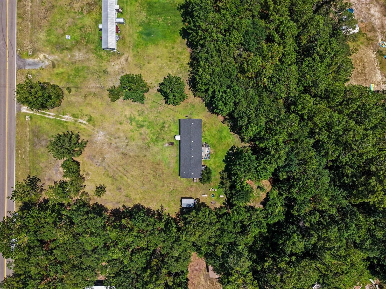 Welcome to your own private retreat in the heart of Middleburg! Nestled on approximately 1.2 acres, this spacious 4-bedroom, 2-bathroom double-wide manufactured home offers 1,584 heated square feet of comfortable living space surrounded by mature trees and peaceful country scenery. Inside, you'll find an inviting open floor plan featuring a generously sized living area, a spacious kitchen with abundant cabinetry, center island, breakfast bar, and dining area—perfect for everyday living and entertaining. The desirable split-bedroom layout provides added privacy, while the oversized primary suite features a large walk-in closet, dual vanities, a garden tub, and separate shower. A versatile bonus room offers endless possibilities as a home office, library, hobby room, media room, or flex space to fit your lifestyle.
Step outside and enjoy the expansive backyard complete with a rear deck, detached storage shed, and plenty of open space for gardening, recreation, pets, or future improvements. With no HOA, you'll have the freedom to make this property your own while enjoying the tranquility of country living just a short drive from shopping, dining, schools, and major roadways. Whether you're looking for extra space, privacy, or the opportunity to enjoy Florida's rural lifestyle, this property offers exceptional value and endless potential. Schedule your private showing today!
