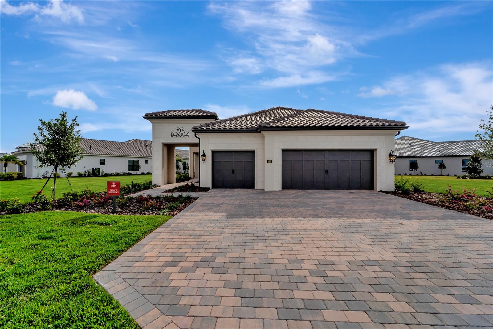 One or more photo(s) has been virtually staged. Modern Luxury meets timeless Elegance. With a beautiful Northern Italian Elevation, this home offers all the upgrades that you would expect. The Vincenzo model is a Neal Signature community home with volume 12 ft ceilings throughout and 8 ft doors giving the home a grand feeling. The home features, 3 Bedrooms, 2 Baths and a Den with 3-car garage. Placed on a large (.42 acre) oversized lot providing greenspace on both sides of the home with the most amazing water view that will re-charge you every day with natures beauty.
When you walk in the front door you are greeted with the reflection of water on your beautiful, upgraded, glossy tile in your Great room. The open floor plan is conducive to entertaining. Your gourmet kitchen is everything you want from beautiful, double stacked cabinets with glass and lighting, wall oven, custom hood and stainless-steel appliances. There is also a beverage room with sink, beverage refrigerator and wine cooler. The guest bedrooms have luxury vinyl flooring, there is No carpet in this home. The Master bedroom is spacious with custom closet shelving and ensuite bathroom with upgraded fixtures and free-standing tub. For those who love to live outside, open the Pocket sliding doors to your large lanai with lap pool and outdoor kitchen on upgraded crushed shell pavers. For your peace of mind, there is IMPACT Glass throughout. List of upgrades is attached. This is a BRAND-NEW home and has not been lived in. The community offers wonderful amenities including Clubhouse, Fitness Center, Community Pool, Spa, Pickle Ball, and Lifestyle coordinator. Let this home be the canvas for your Lifestyle. The location is perfect. An easy drive to beaches, shopping, restaurants and to Sarasota's downtown nightlife, the arts, and farmers markets. This is a Lifestyle home, make it yours!