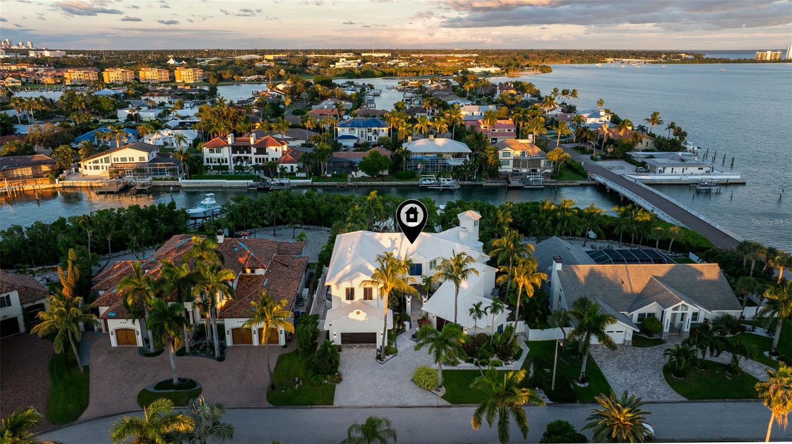 With 100 feet of deep-water frontage, boating enthusiasts will appreciate the private dock equipped with two boat lifts, two jet ski lifts, a kayak launch, and a private beach—all just minutes from the open Gulf of Mexico. Elegance, innovation, and coastal luxury converge in this remarkable Bayway Isles residence—masterfully renovated between 2021 and 2023 and reimagined for today’s modern lifestyle. Spanning over 5,500 square feet, this estate features six bedrooms, five full baths, and two half baths, blending refined design with state-of-the-art smart home technology. Upon entry, a sense of grandeur unfolds—soaring ceilings, rich hardwood floors, and custom architectural details set an elegant tone throughout. The main-level primary suite serves as a serene retreat, while two upper wings provide exceptional flexibility—one designed for extended family or in-law living, the other ideal for guests or a recreation area, complete with a fully furnished game room. Thoughtful touches such as wet bars, stone countertops, and three fireplaces accentuate the home’s craftsmanship, all seamlessly integrated through a Control4 automation system for effortless living. Outdoor living takes center stage with expansive decks, lush tropical landscaping, and a resort-style pool featuring dual propulsion swim systems. With 100 feet of deep-water frontage, boating enthusiasts will appreciate the private dock equipped with two boat lifts, two jet ski lifts, a kayak launch, and a private beach—all just minutes from the open Gulf of Mexico. Additional highlights include three dedicated offices, dual two-car garages with EV readiness, and the peace of mind of 24-hour gated security within the highly sought-after Bayway Isles community. Ideally situated just minutes from downtown St. Petersburg, the Gulf beaches, and Fort De Soto, with easy access to Tampa, Bradenton, and Sarasota, this home exemplifies elevated waterfront living. Notably, this residence did not experience flooding during the 2024 hurricane season—a testament to its solid design and enduring craftsmanship. More than a home, this is a statement of modern coastal style—a place where thoughtful design, luxury amenities, and timeless architecture unite in perfect harmony.