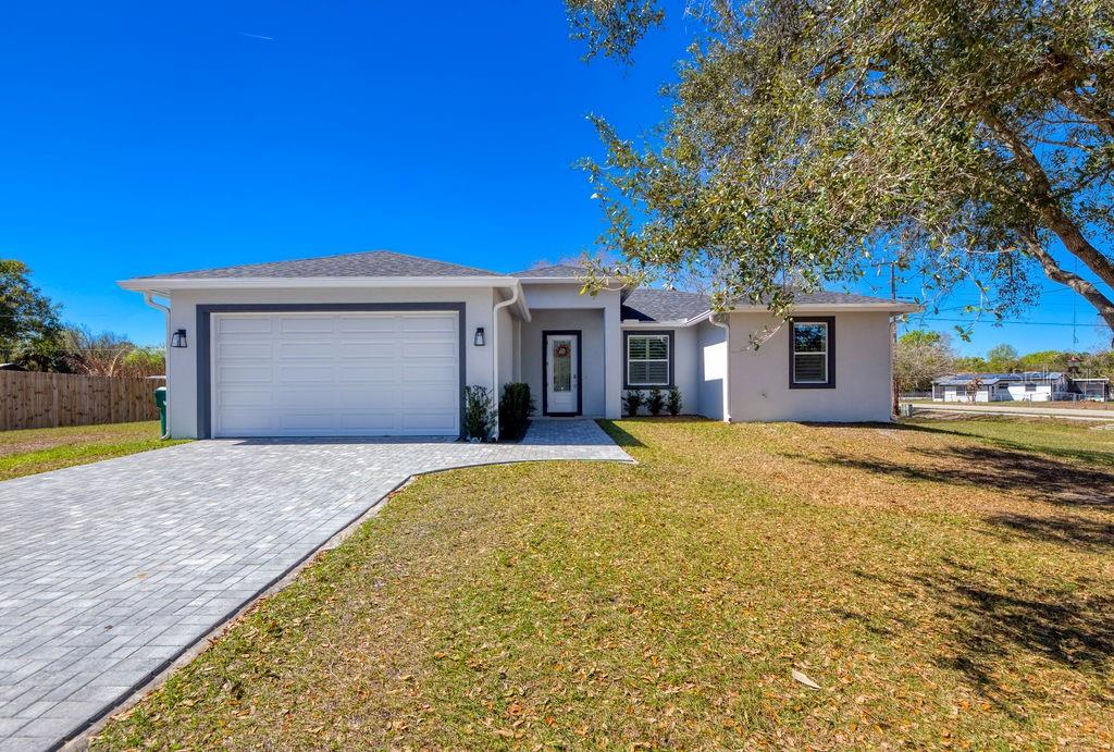 This stunning 3-bd, 2-ba home on oversized .36 acre lot is packed with custom upgrades far beyond standard builder grade. Soaring 10-foot ceilings, 8-foot doors, plantation shutters, and gorgeous 36-inch tile flow throughout the home. The open-concept living area features a vaulted ceiling and decorative fireplace, creating a bright yet inviting space. The kitchen shines with solid wood, soft close cabinetry, quartz countertops, and stainless-steel appliances. The spacious primary suite offers a tray ceiling, custom walk-in closet, and a beautifully tiled shower with river rock flooring. Impact windows and doors, spray foam insulation, and an on-demand water heater provide excellent energy efficiency. Enjoy the 21x10 covered lanai, brick paver driveway, gutters, and more.