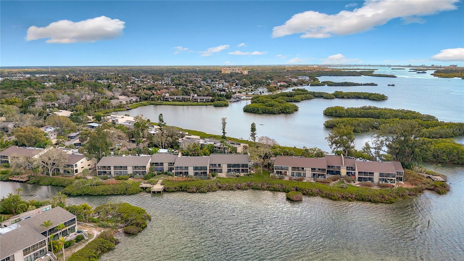 Welcome to Sarasota's best kept secret. The grounds at Pelican Cove are something you have never seen before. Your new 3 bedroom, 2 bath condominium is an end unit located on the 2nd floor with cathedral ceilings and clerestory windows, meaning the sunlight pours in. Spectacular view of Pelican Bay. Bonuses are pelicans fishing * fish jumping * dolphins swimming wild kingdom views off your lanai. New vinyl floors installed in May 2025 as well as a new washer and dryer. Main bedroom has its own private lanai and walk-in shower with oversized bedroom closet. There are 2 guest bathrooms - one with a tub/shower and the other with a shower only.  Only 12 or so of these floor plans out of 731 condos. Pelican Cove is a 75-acre, gated, vibrant-waterfront community nestled among manicured tropical foliage. Truly offering something for everyone. Abundant amenities include the 86-slip boat harbor with excellent rates & a launch dock for kayaks and canoes, 6 heated swimming pools, hot-tub, 3 clubhouses, lighted tennis/pickleball courts, basketball, dog walk area, walking trails and boardwalks, as well as fishing gazebos, water exercise classes, exercise facility, 2 art studios and a pottery classroom. Take classes at Pelican Cove University or join one of the more than 37 clubs for photography, fiber art, bike riding, culinary arts and card clubs. Woodworking, sculpting, and evening jazz & classical music concerts round out the active lifestyle. Come and see what you have been waiting for.