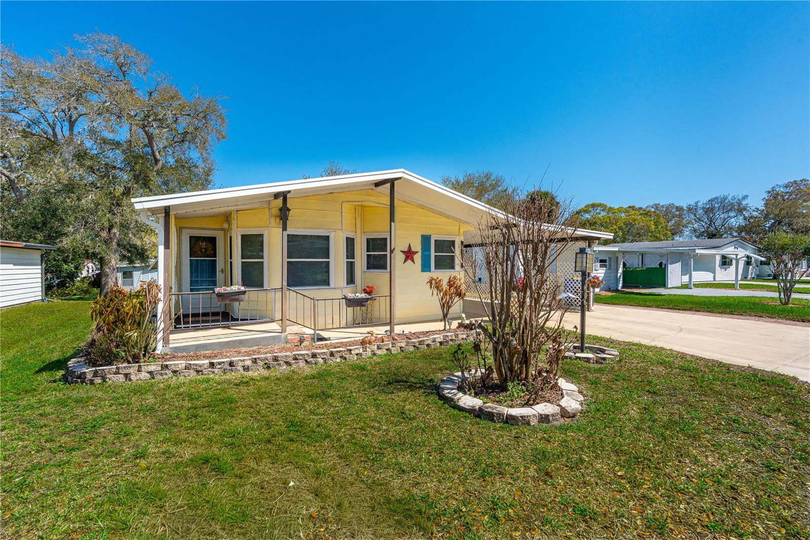 One or more photo(s) has been virtually staged. Florida living awaits in this 2-bedroom, 2-bath home with a versatile air conditioned sunroom (flex space)--and best of all, you own the land! Large living room with dining room and eat in kitchen area. Don't forget the bonus ''workshop'' out back with electricity and window unit. Your electric bill will be low because this property includes fully paid for solar panels.  Newer windows, water heater, and ac.  Walk to the clubhouse, heated pool, hot tub, tennis, bocci, fishing pier. Resident boat access to the Intracoastal. Parking for your boat or RV when available. Low maintenance fees. Move-In Ready. Check this one out!